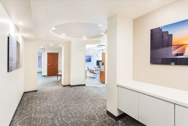 A hallway with a picture on the wall and a painting on the wall.