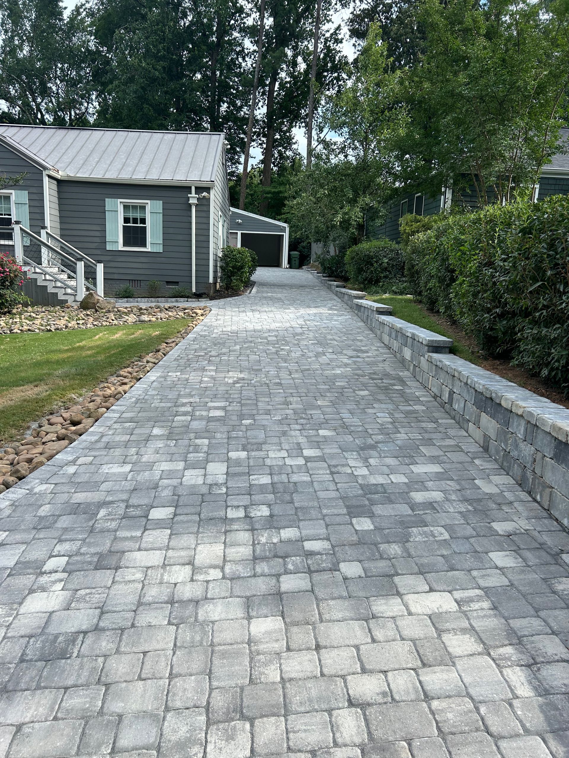 A patio with a grill on it in front of a house.