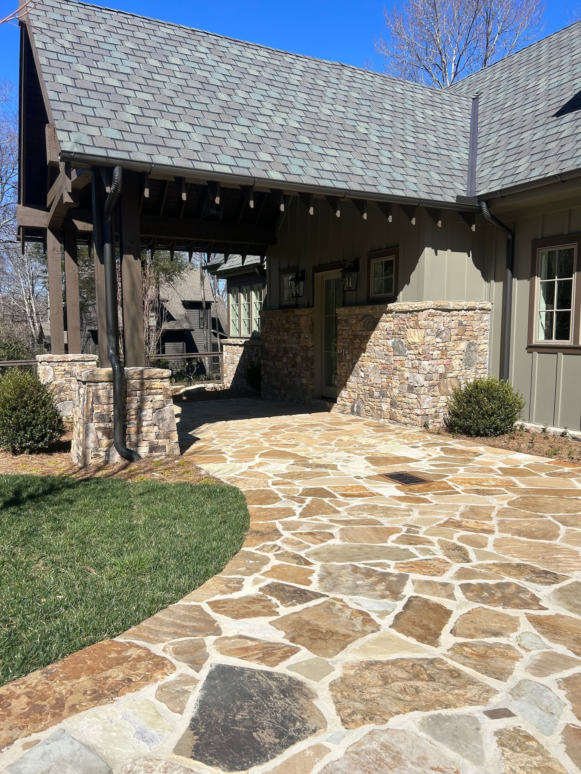 A statue of two people sitting on a bench in front of a building.