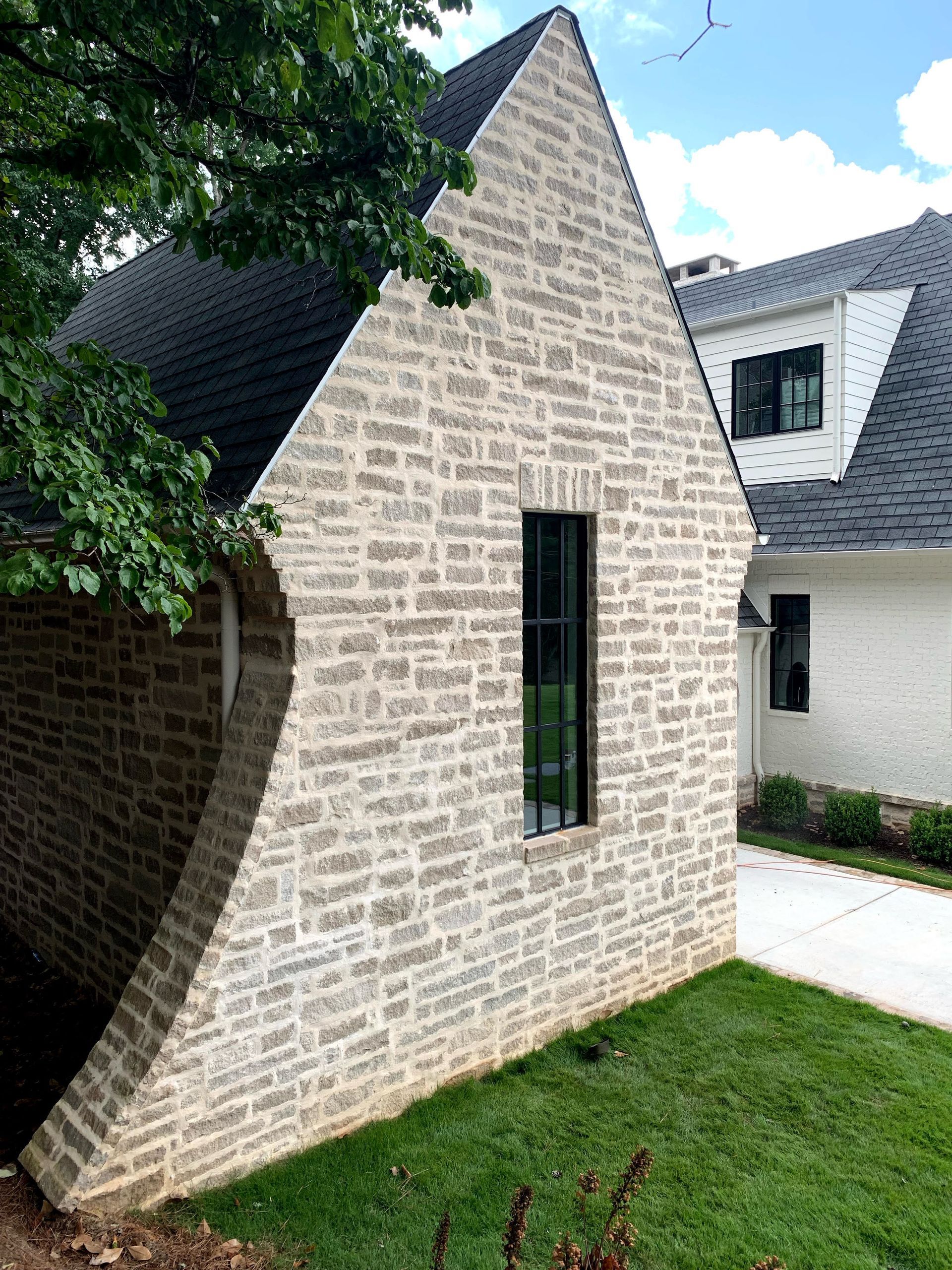 A patio with a bench and stairs in front of a house.