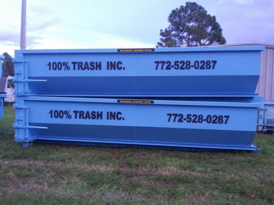 Two blue dumpsters stacked on top of each other for 100 % trash inc.