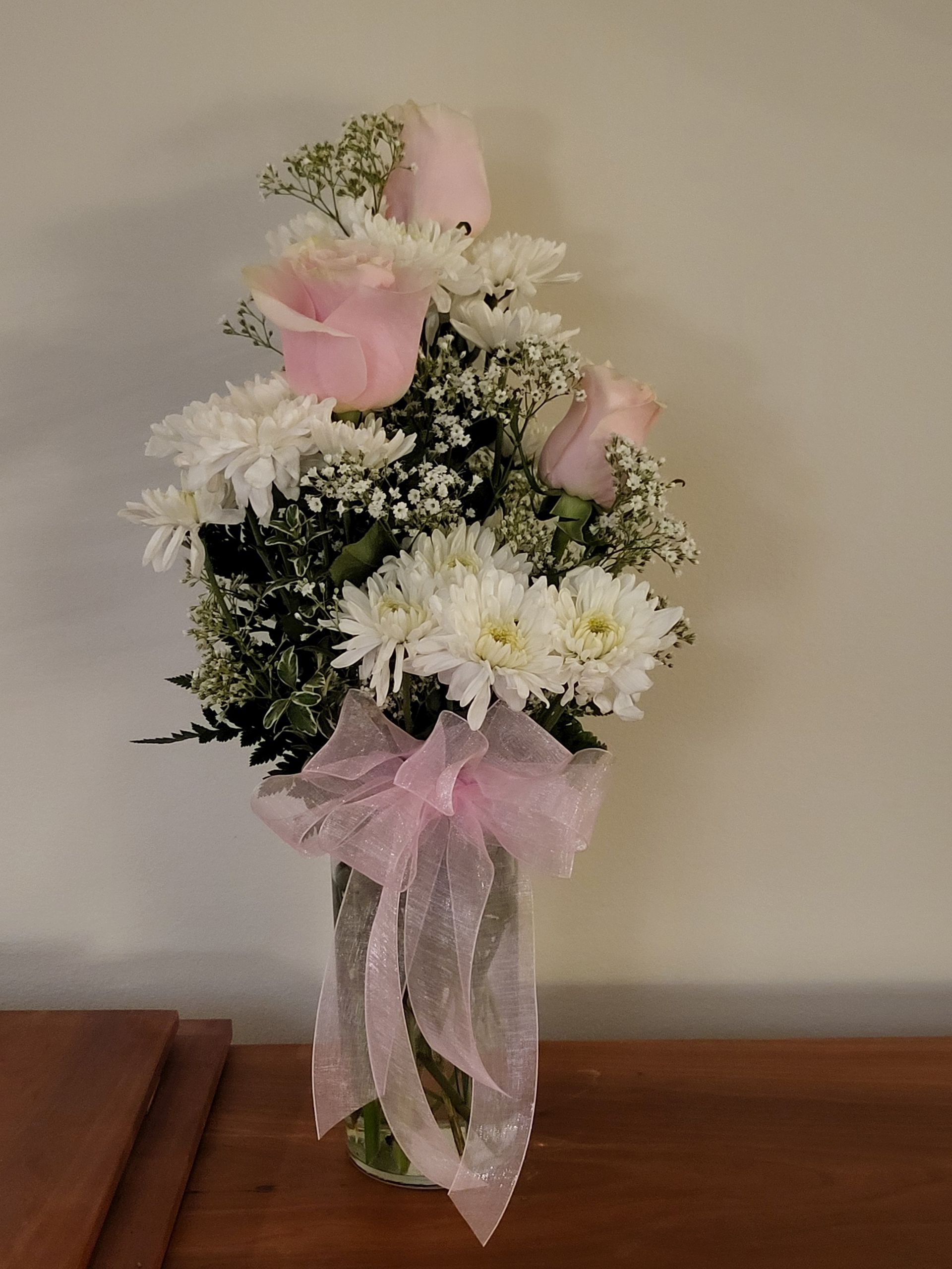 A vase filled with flowers is sitting on a table.