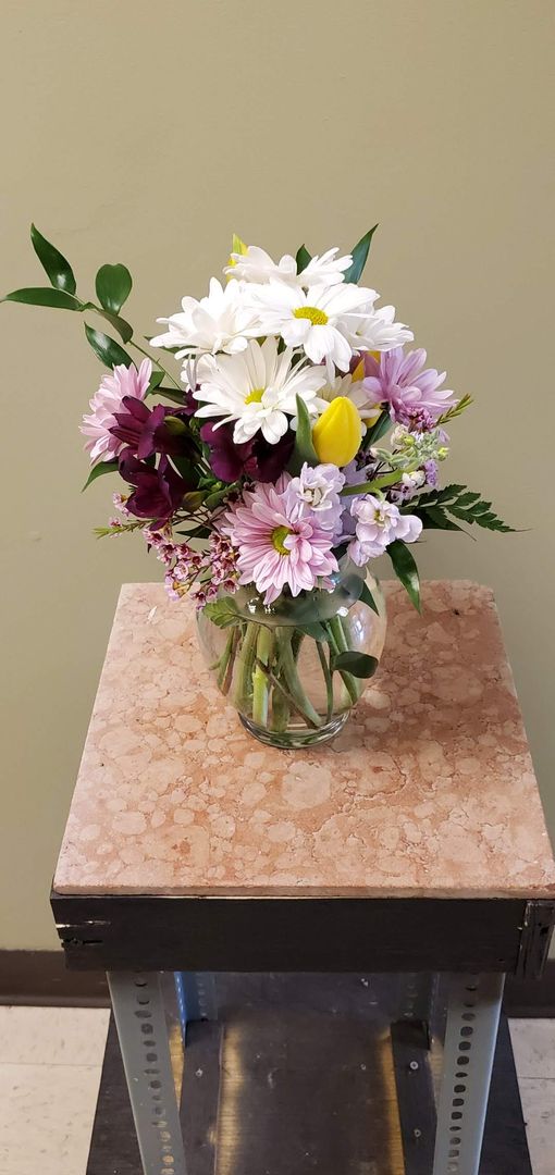 A vase filled with flowers is sitting on a table.