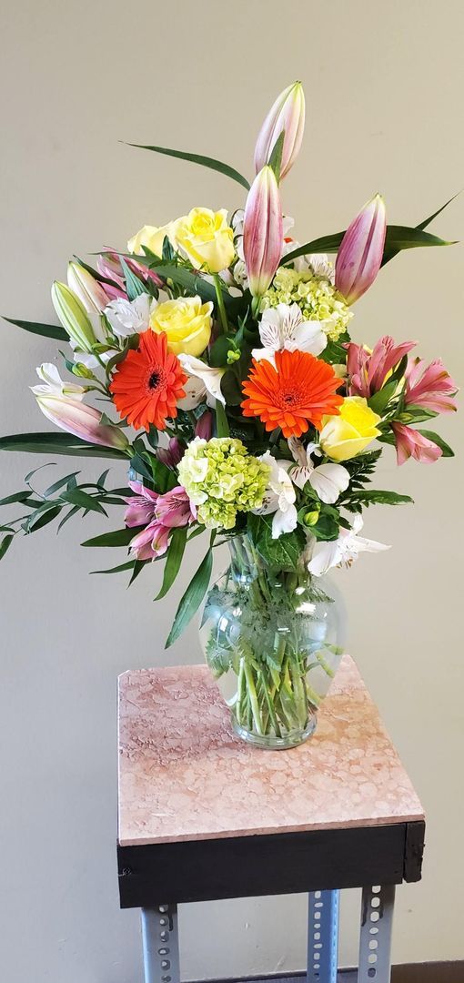 A vase filled with flowers is sitting on a small table.