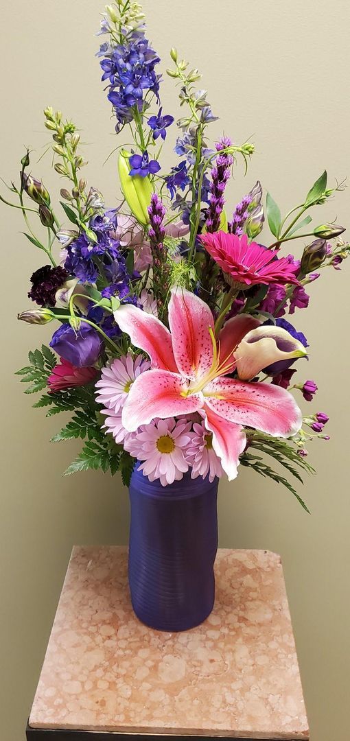 A vase filled with purple and pink flowers is sitting on a table.