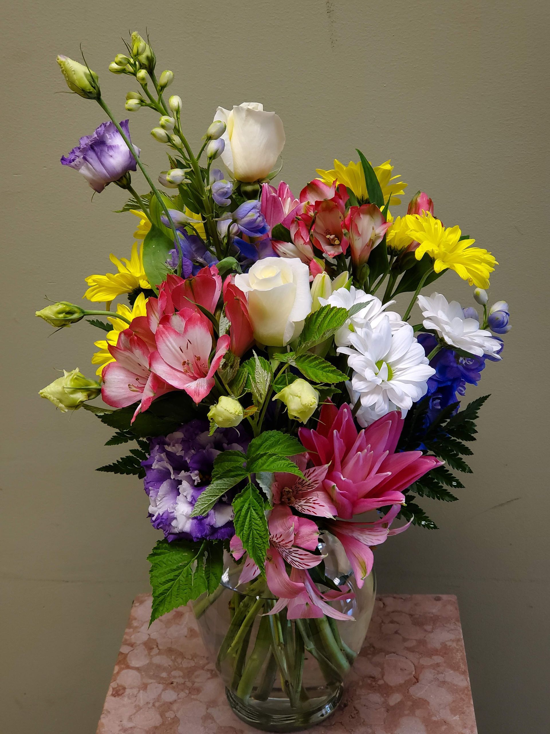 A vase filled with colorful flowers is sitting on a table.