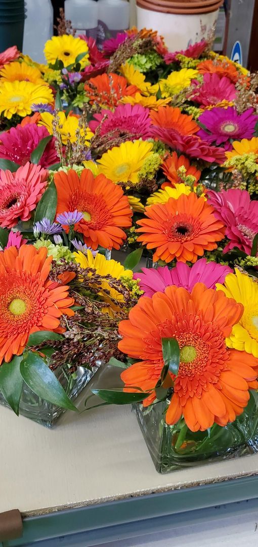 A bunch of colorful flowers are sitting on a table.