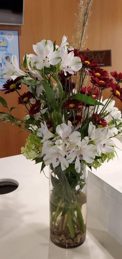 A vase filled with flowers is sitting on a counter.