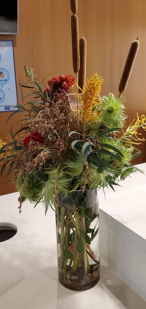 A vase filled with flowers is sitting on a counter.