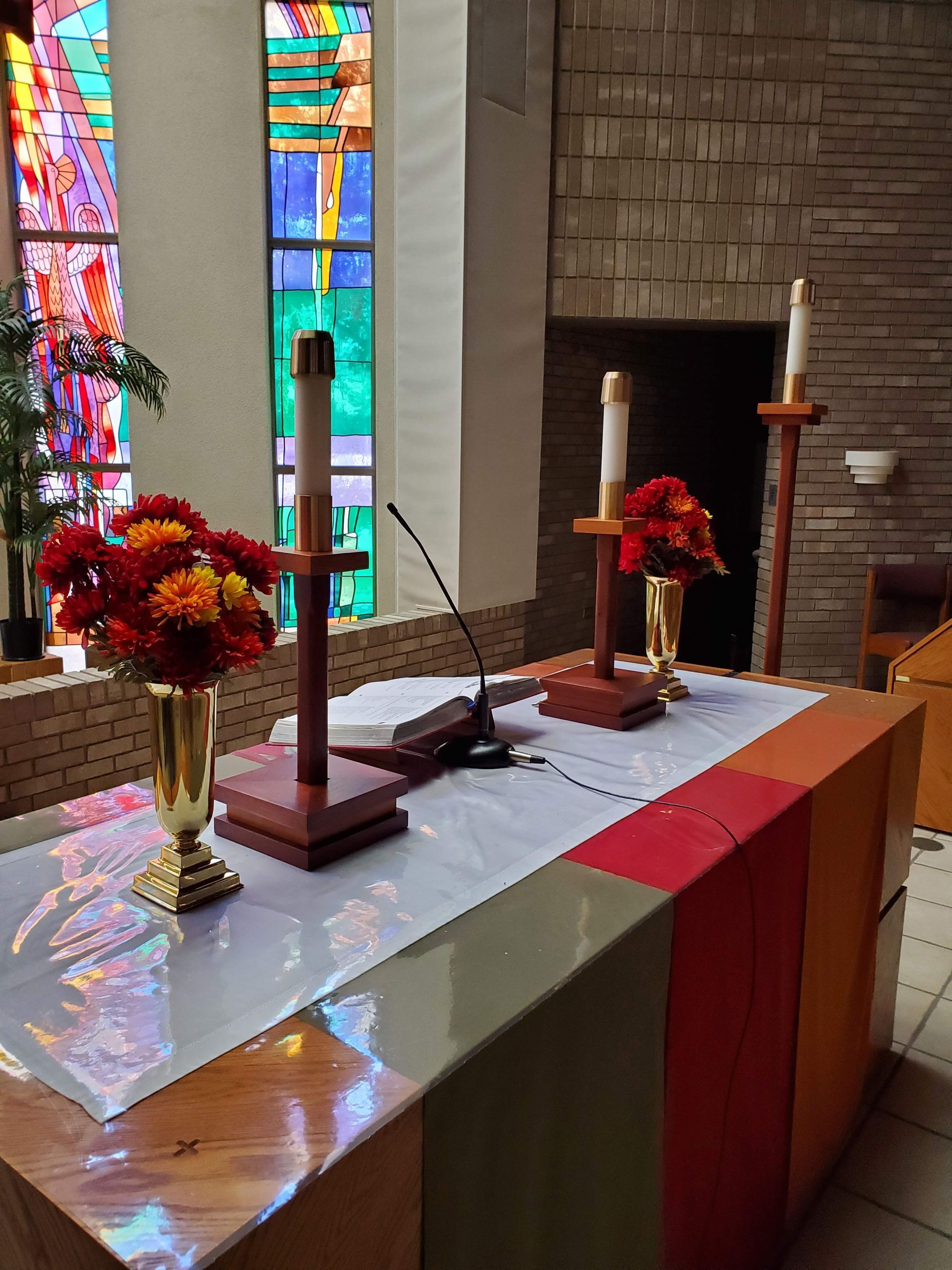 A church altar with candles and flowers on it.