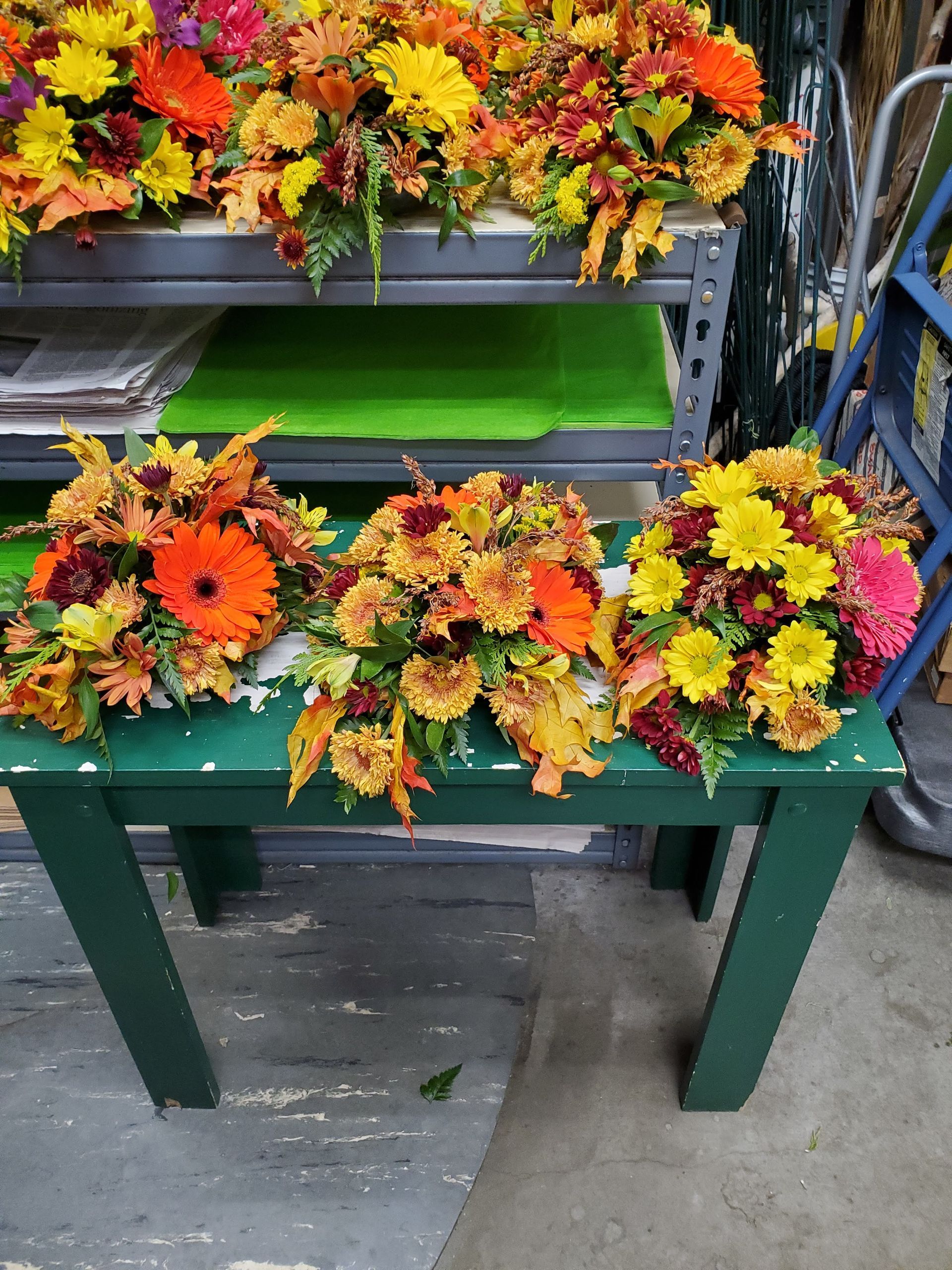 Three bouquets of flowers are sitting on a green table.