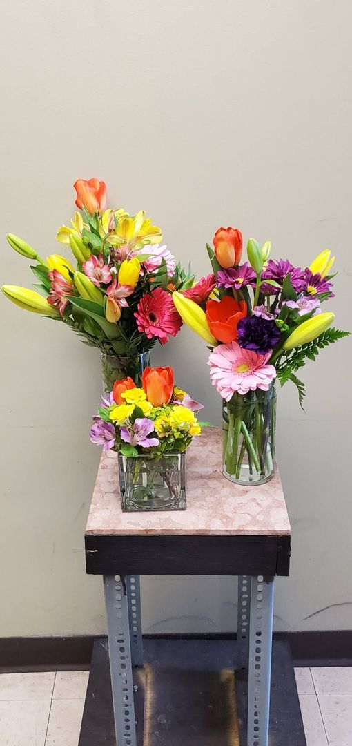 A vase filled with colorful flowers is sitting on a table.