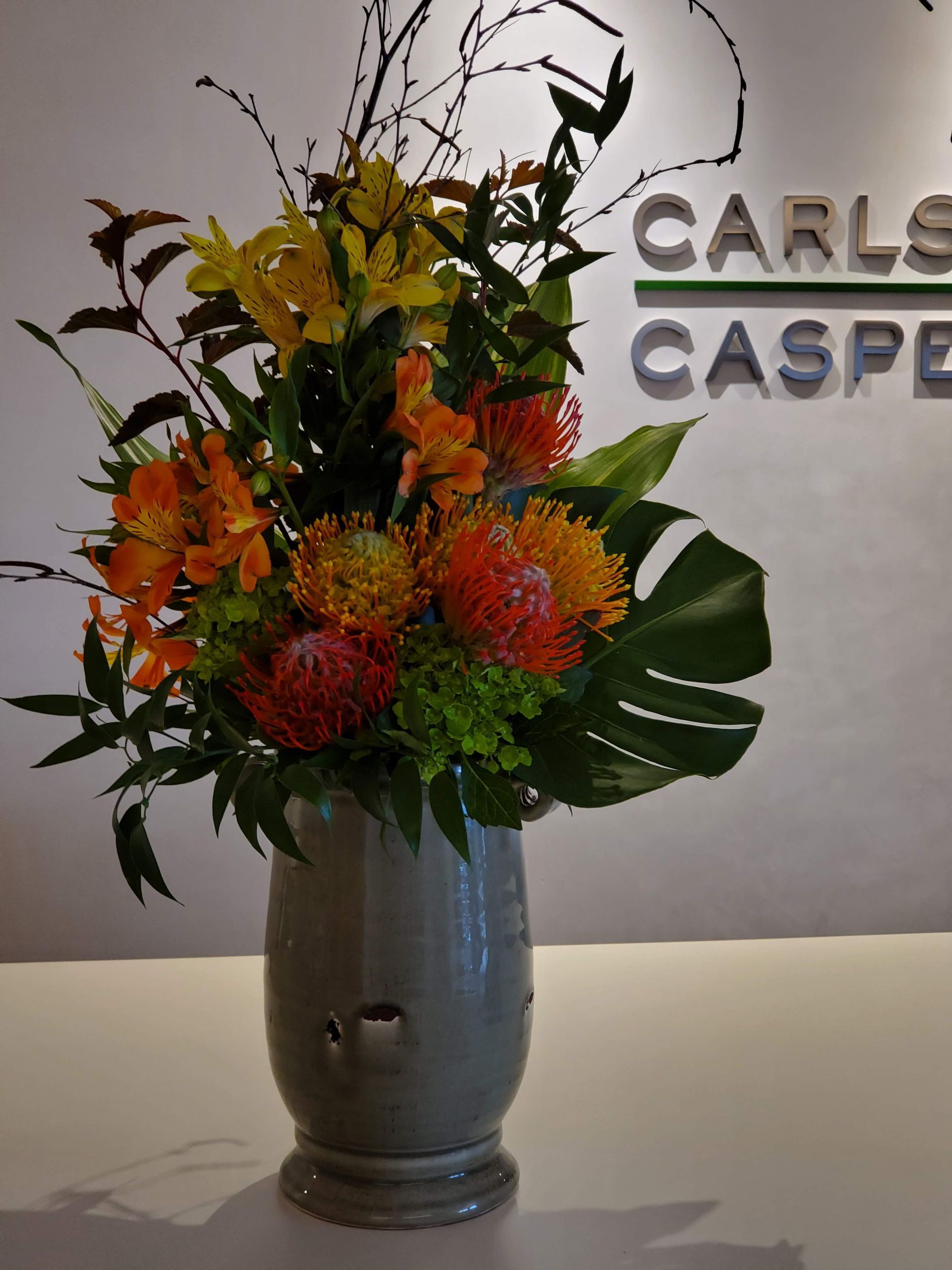 A vase of flowers in front of a wall.