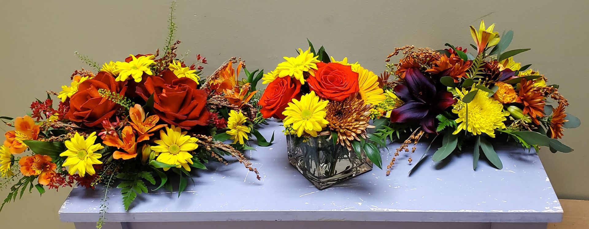 Three vases of flowers are sitting on a table.