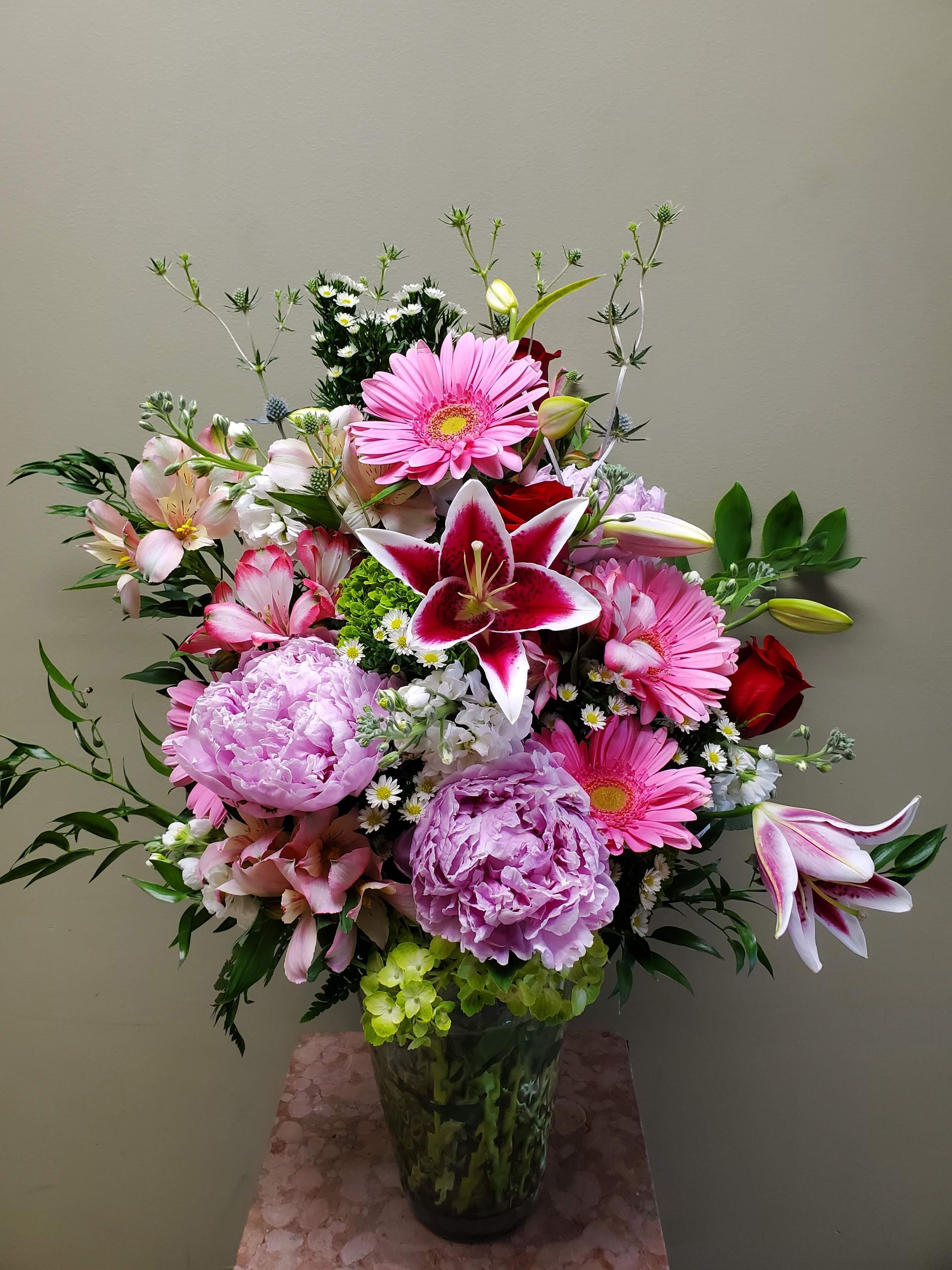A vase filled with pink flowers is sitting on a table.