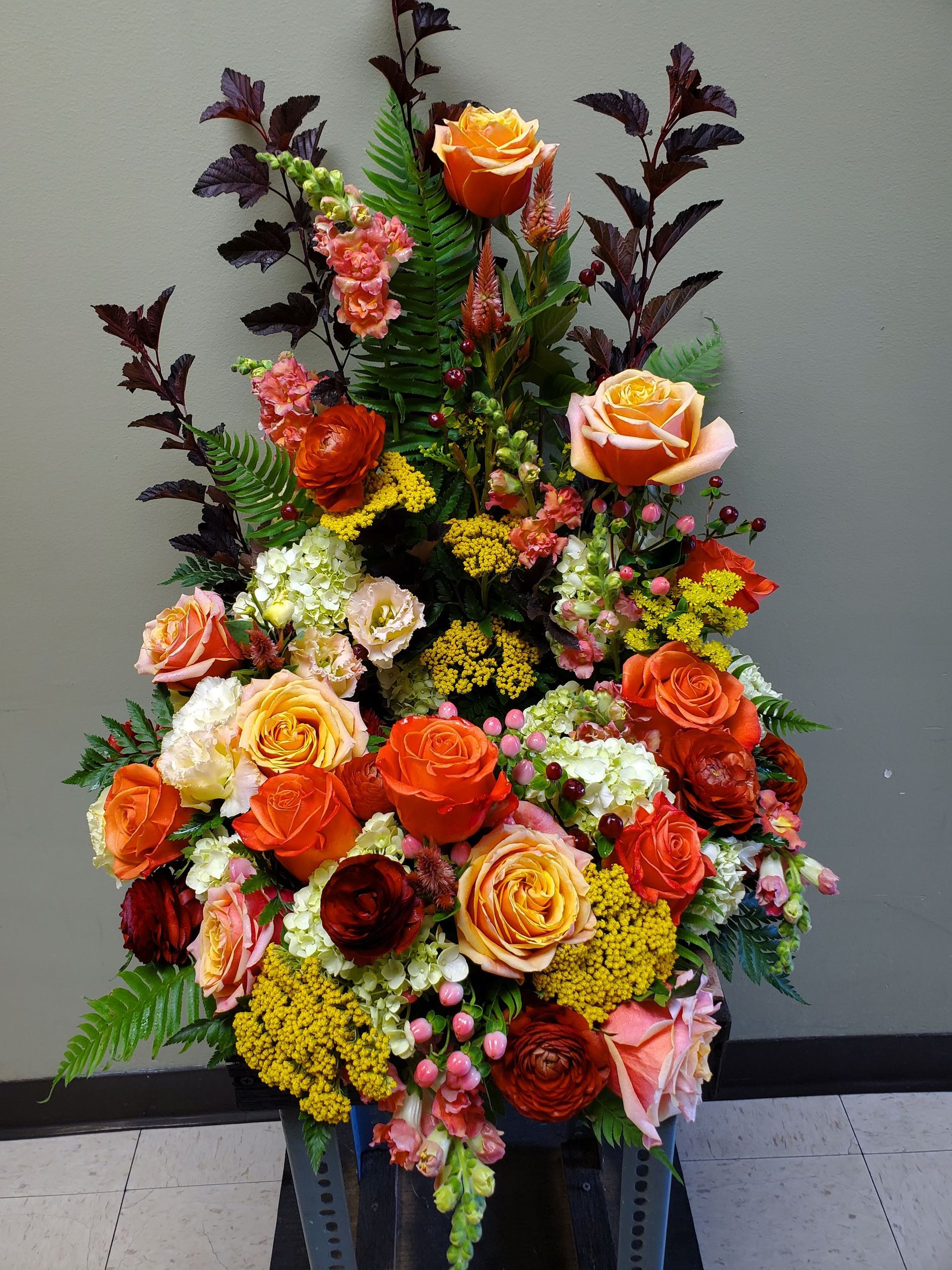 A vase filled with lots of different types of flowers.