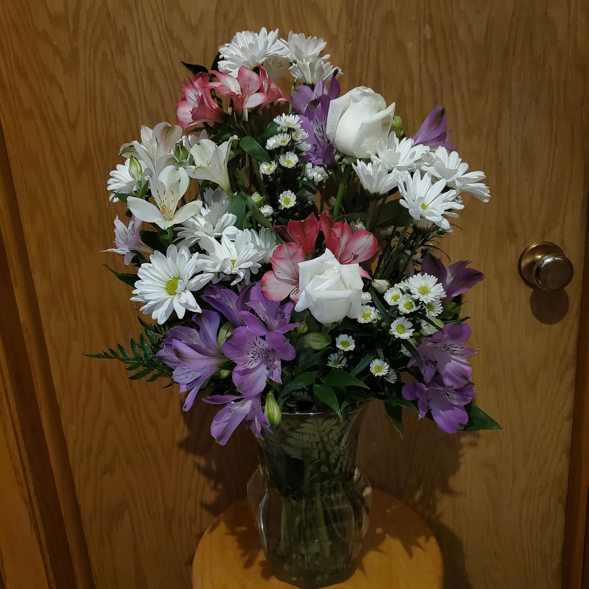 A vase filled with colorful flowers sits on a table.