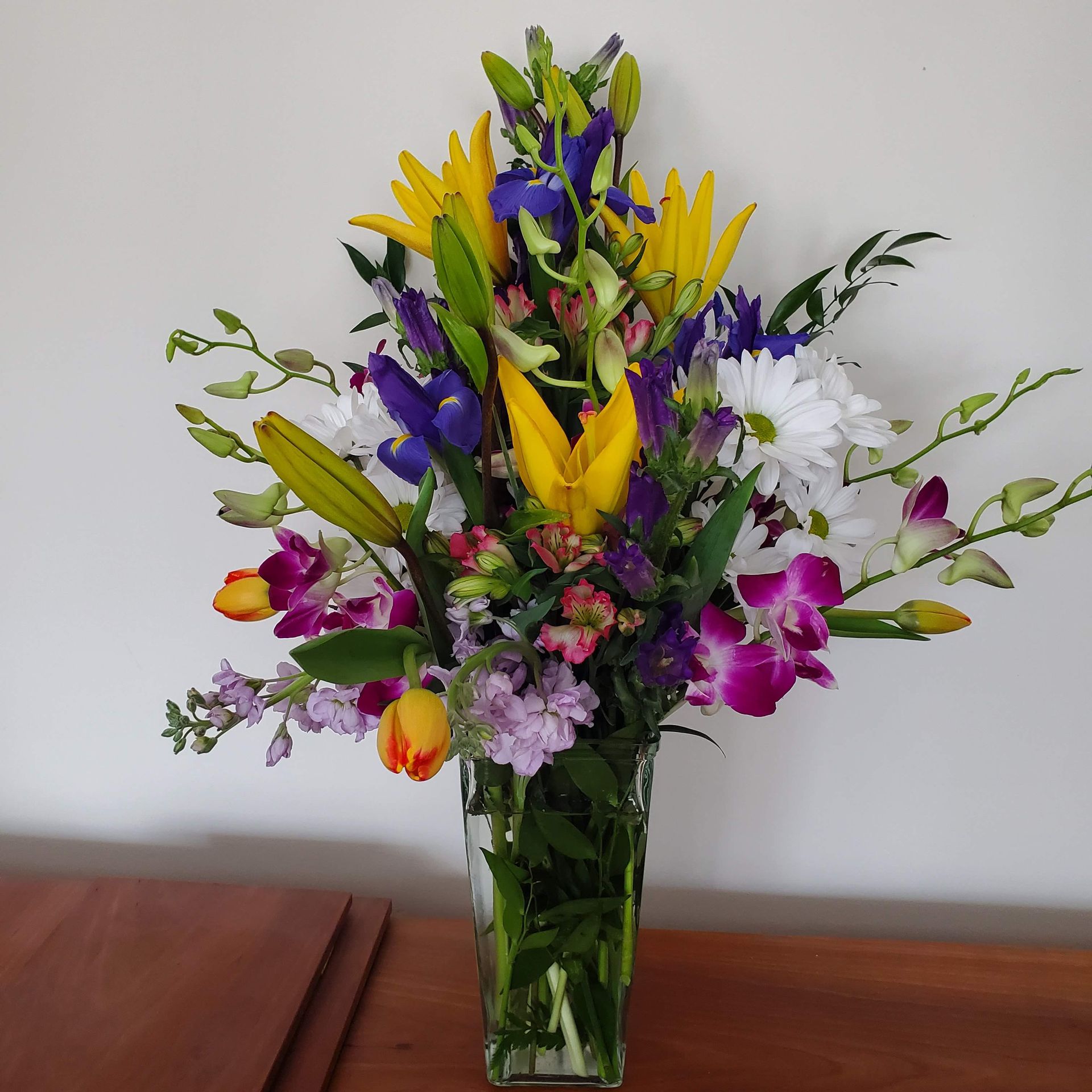 A vase filled with colorful flowers sits on a table.