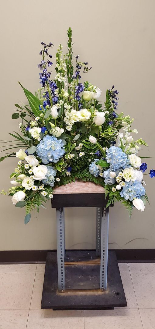 A large arrangement of blue and white flowers is sitting on a table.