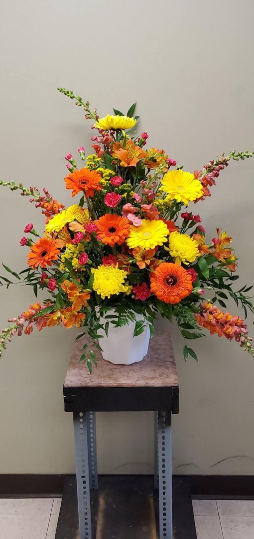A vase filled with colorful flowers is sitting on a small table.