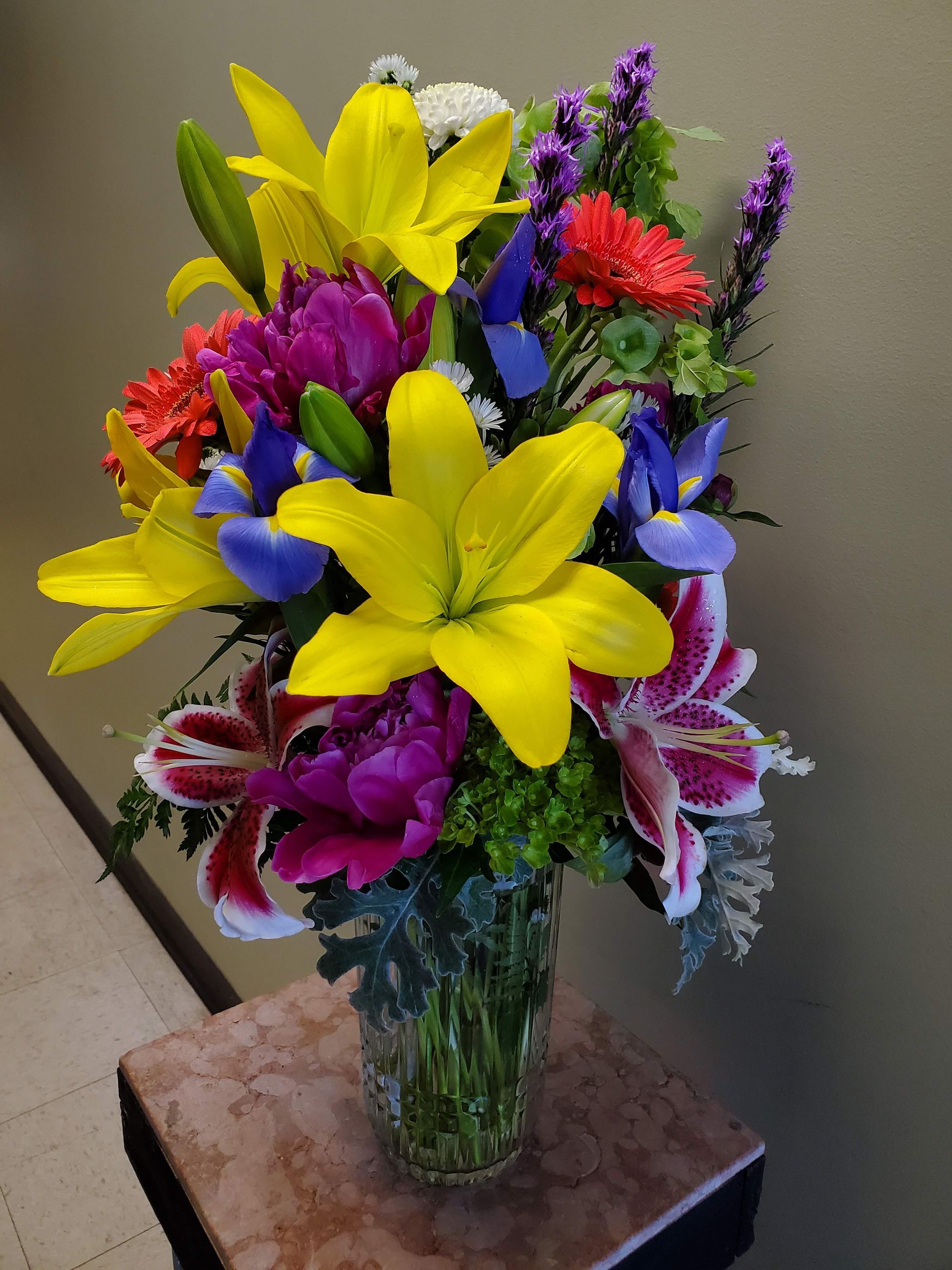 A vase filled with colorful flowers is sitting on a table.