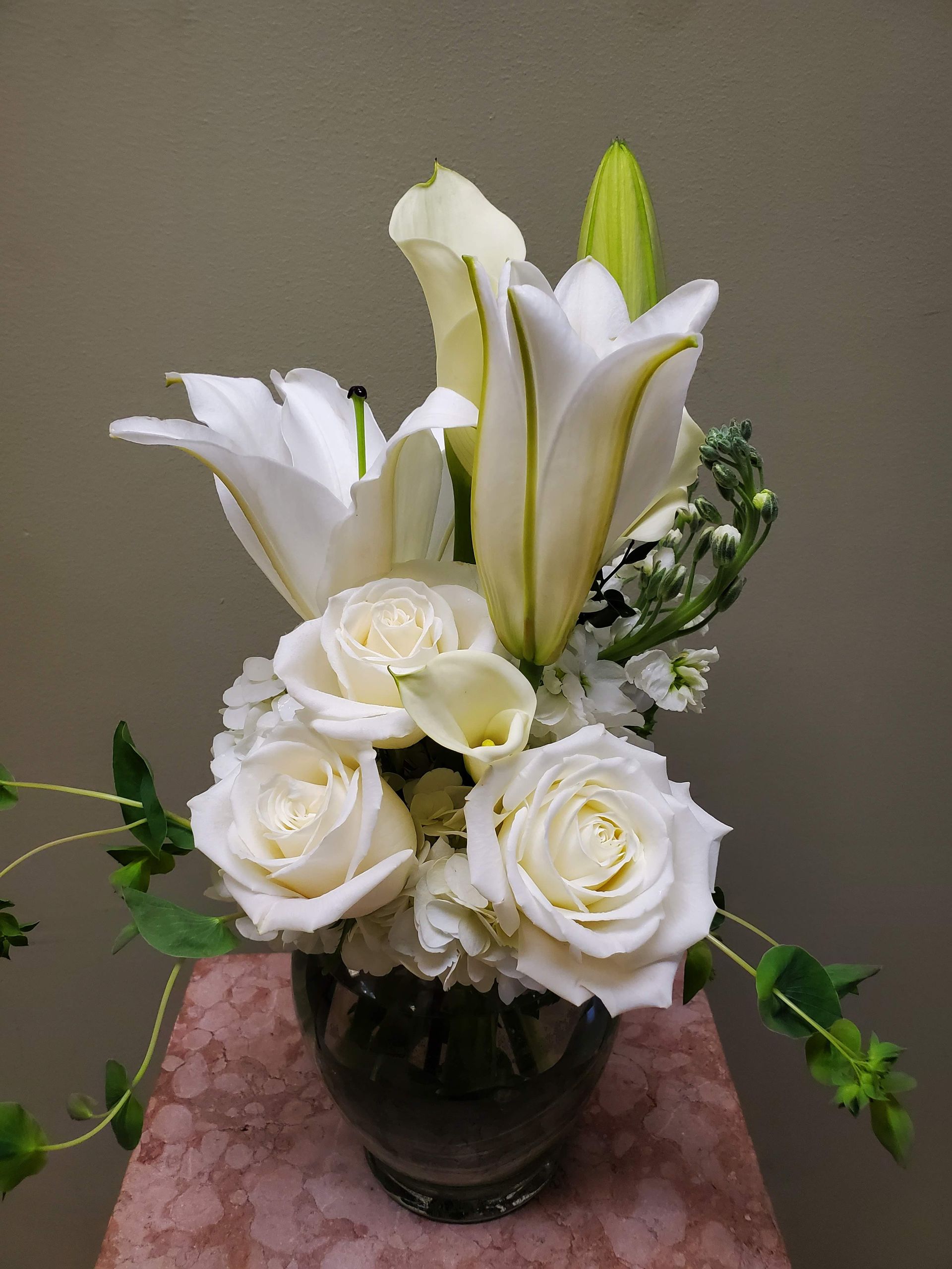 A vase filled with white flowers is sitting on a table.