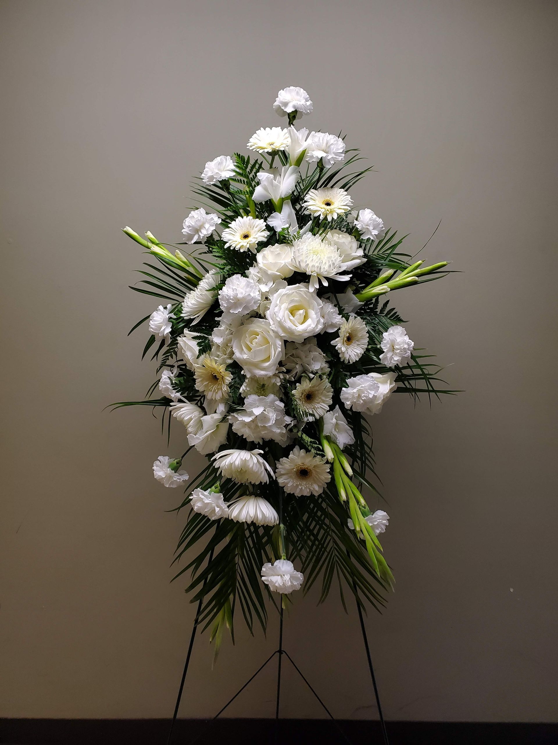 A display of white flowers on a stand in a room.