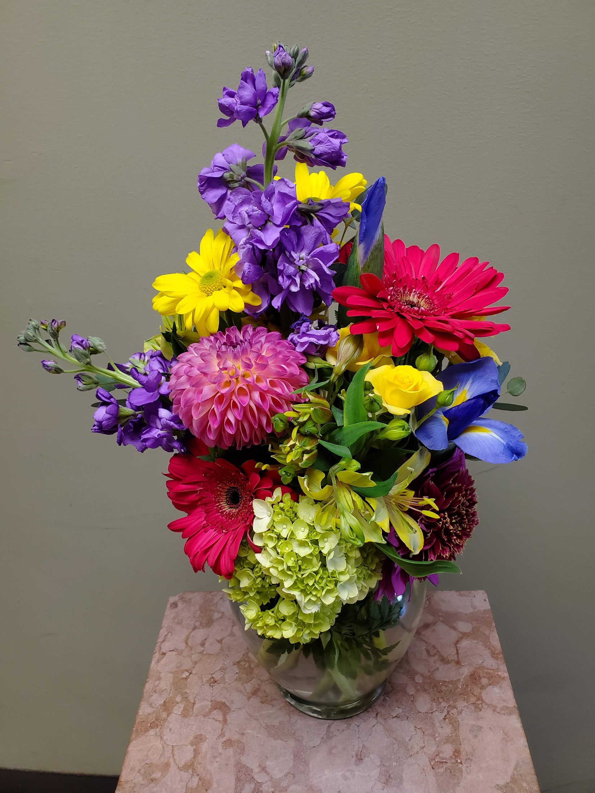 A vase filled with colorful flowers is sitting on a table.