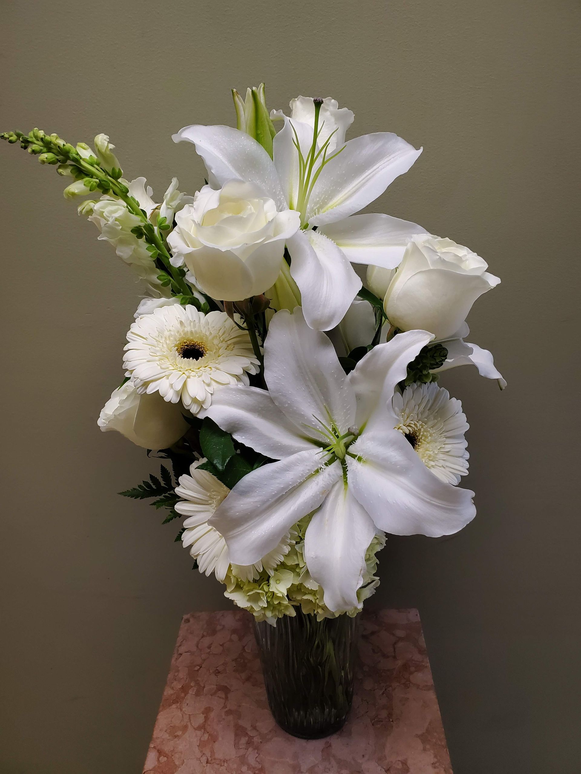 A vase filled with white flowers is sitting on a table.