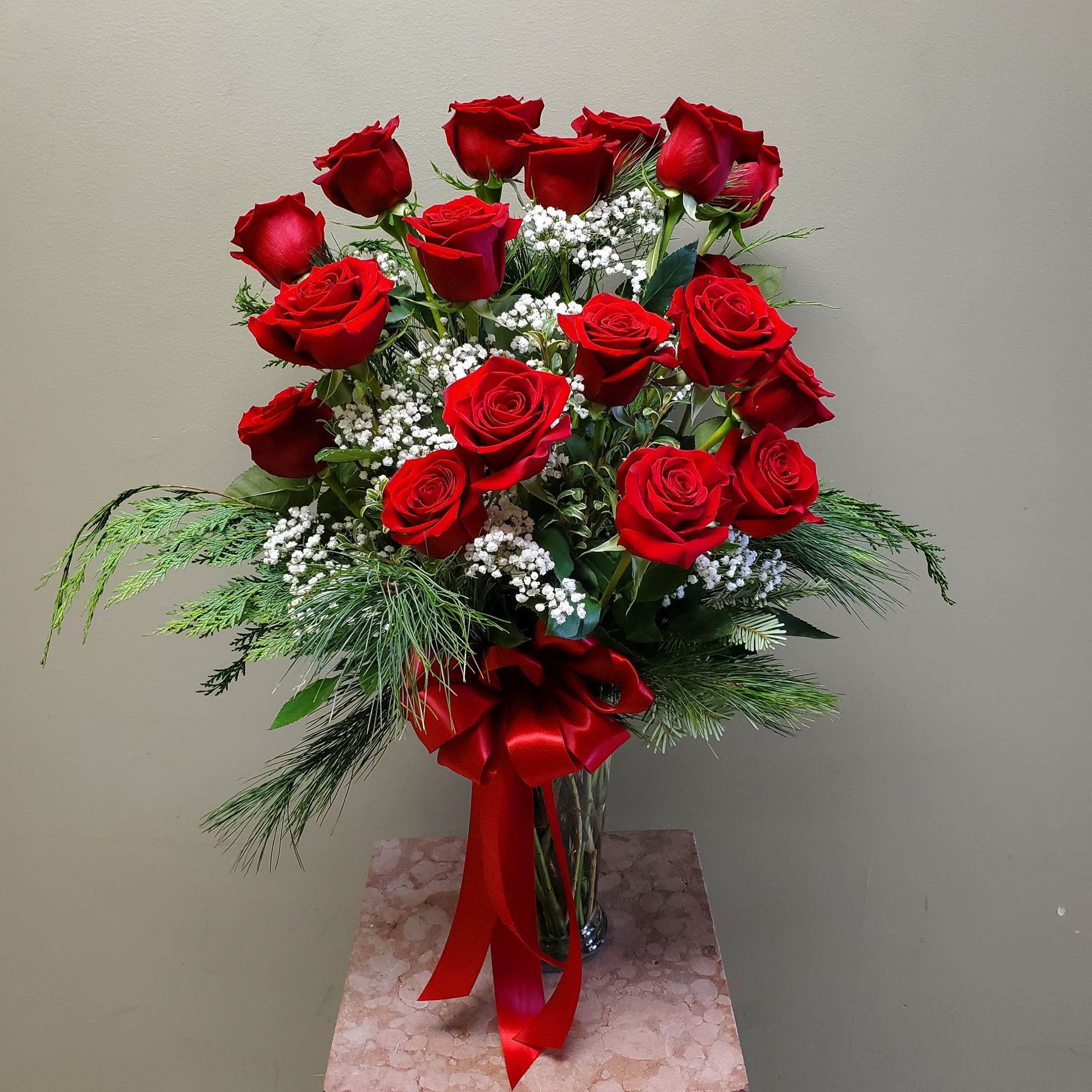 A vase filled with red roses.