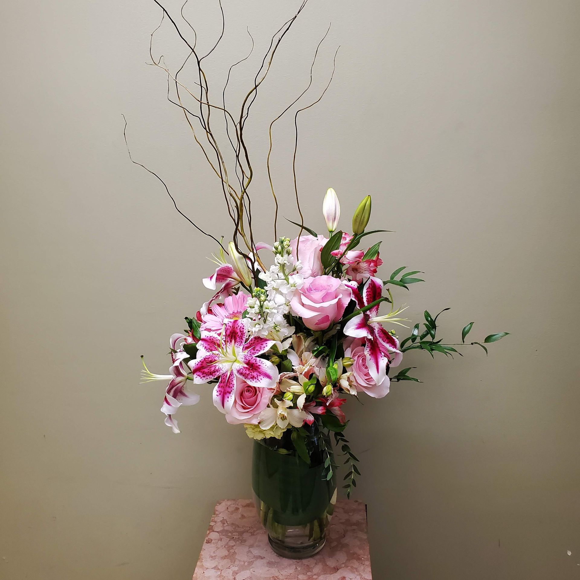 A vase filled with pink and white flowers is sitting on a table.