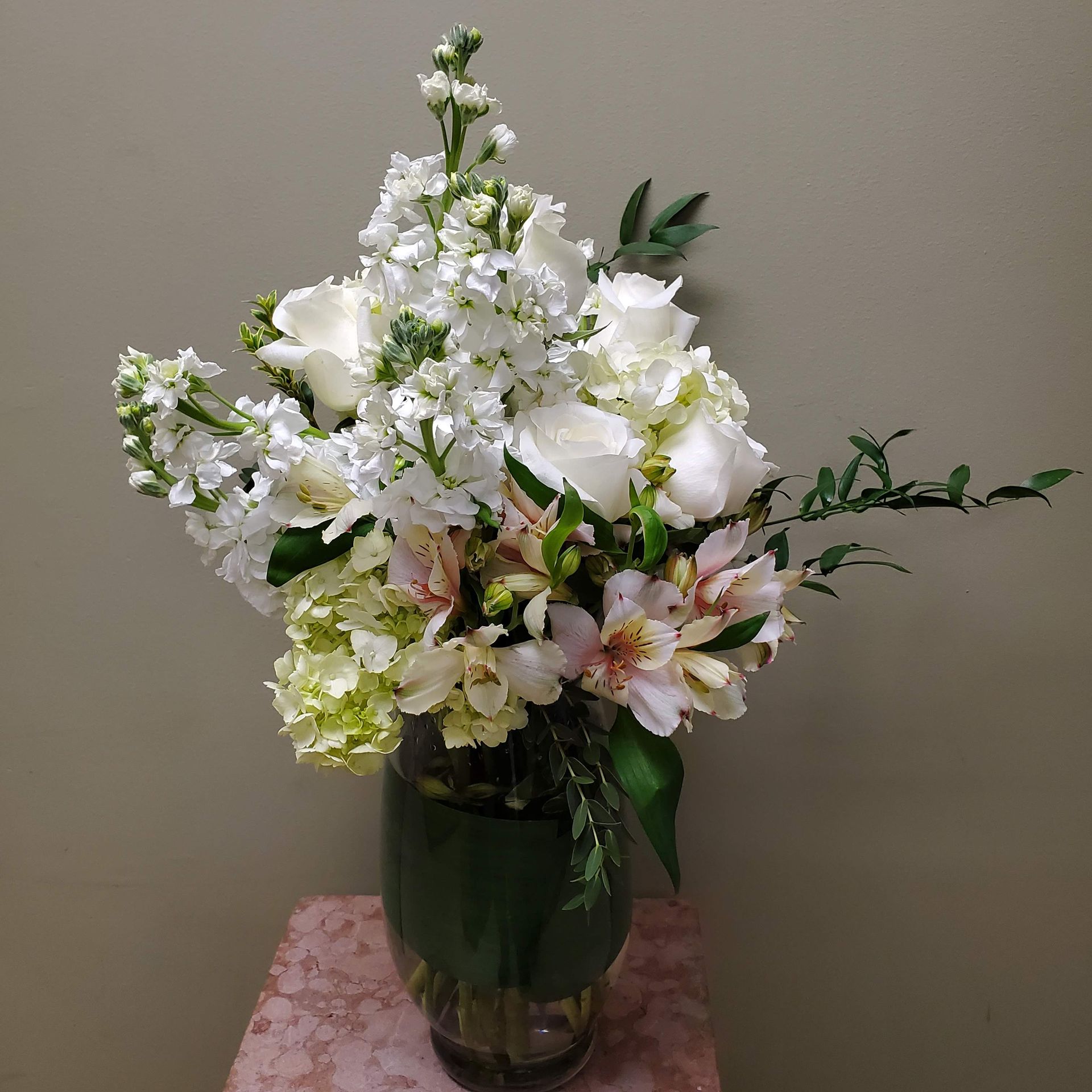 A vase filled with white flowers is sitting on a table.