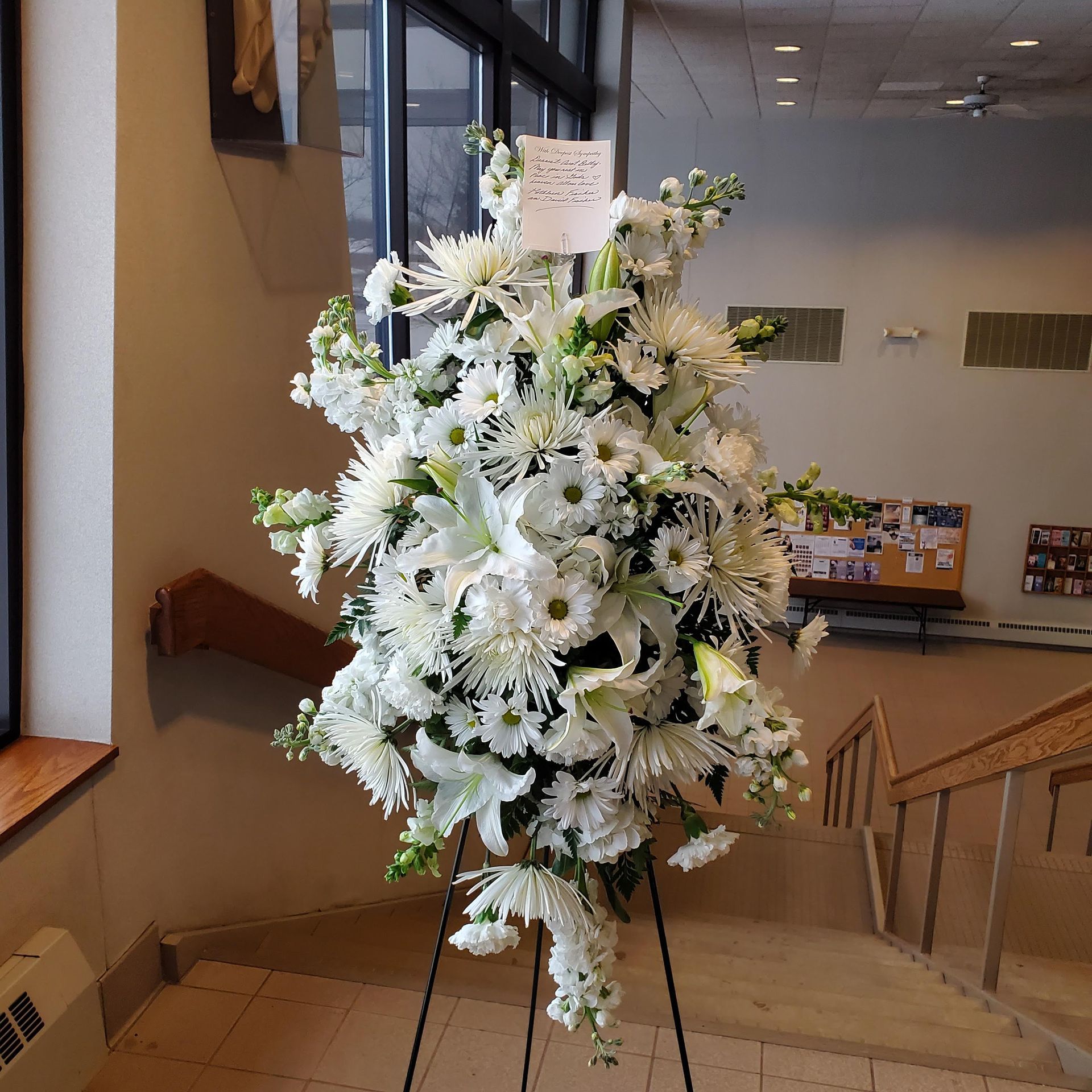 A large bouquet of white flowers on a stand.