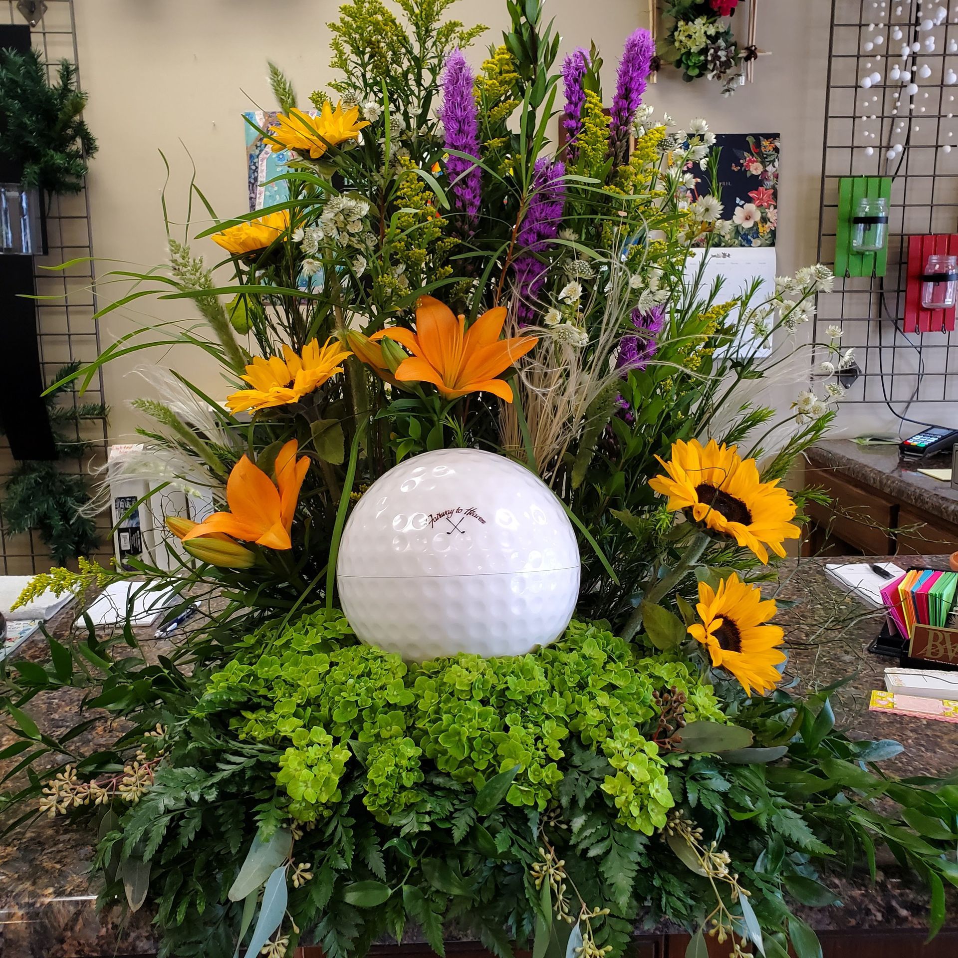 A golf ball is in the middle of a bouquet of flowers.