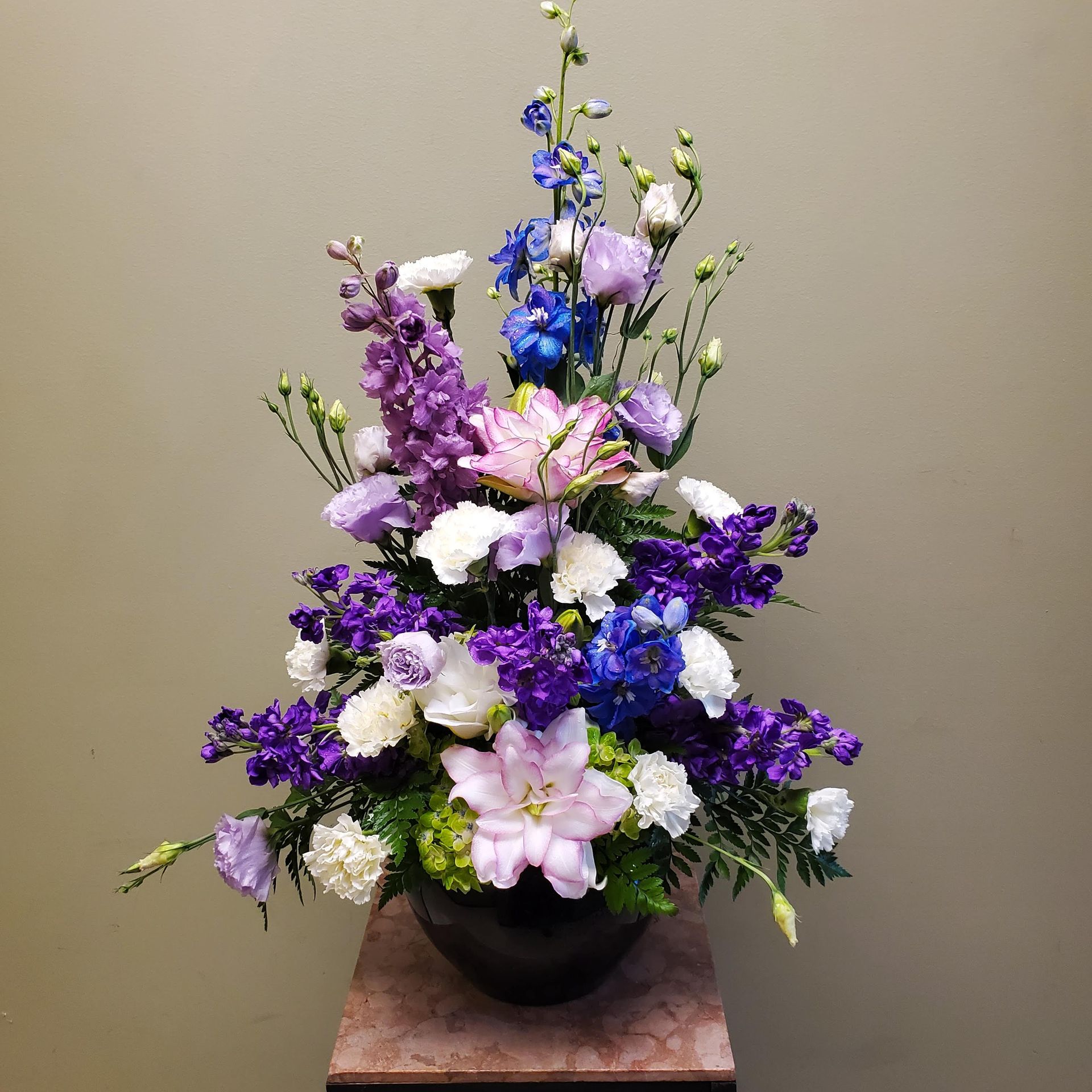 A vase filled with purple and blue flowers sits on a table.