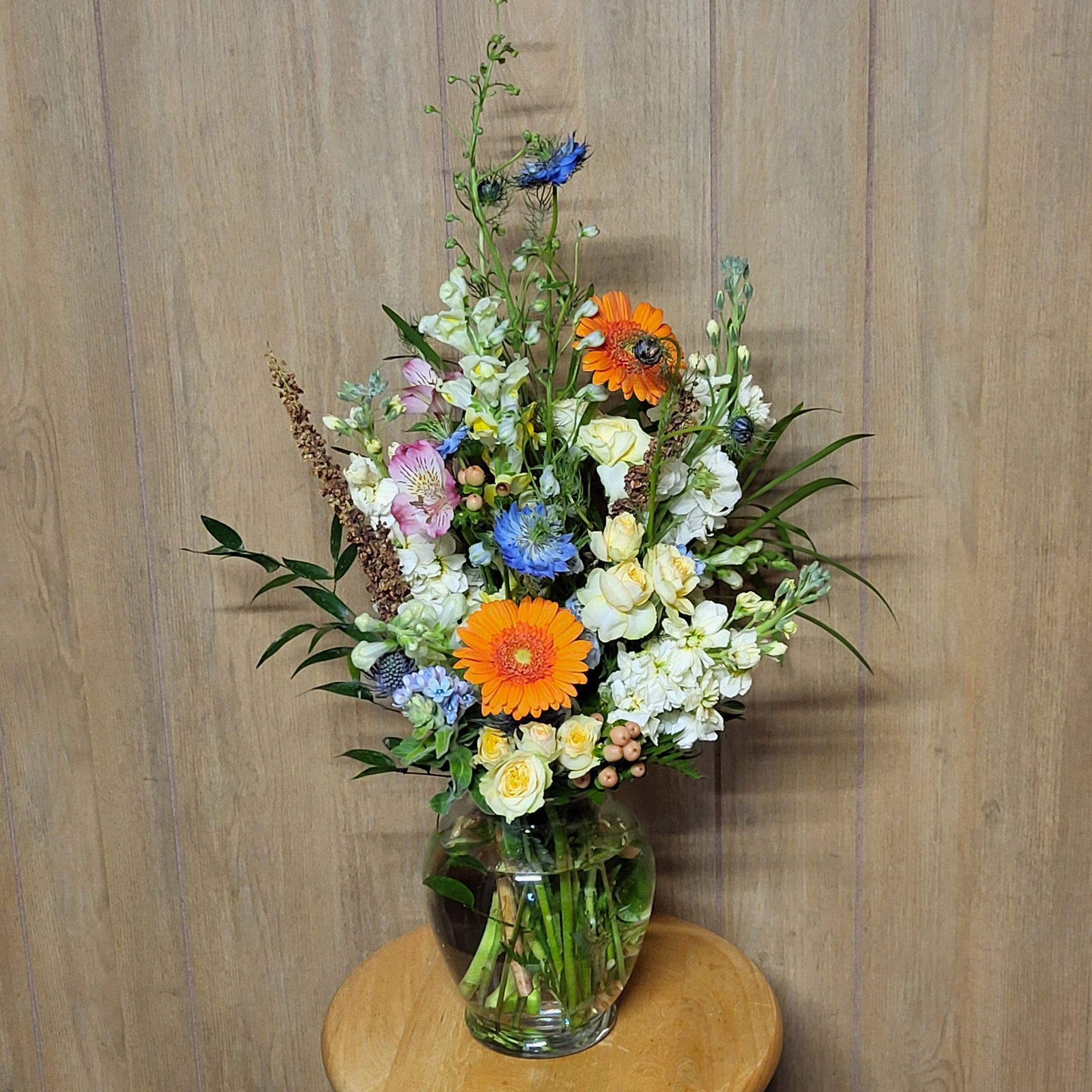A vase filled with flowers is sitting on a wooden table.