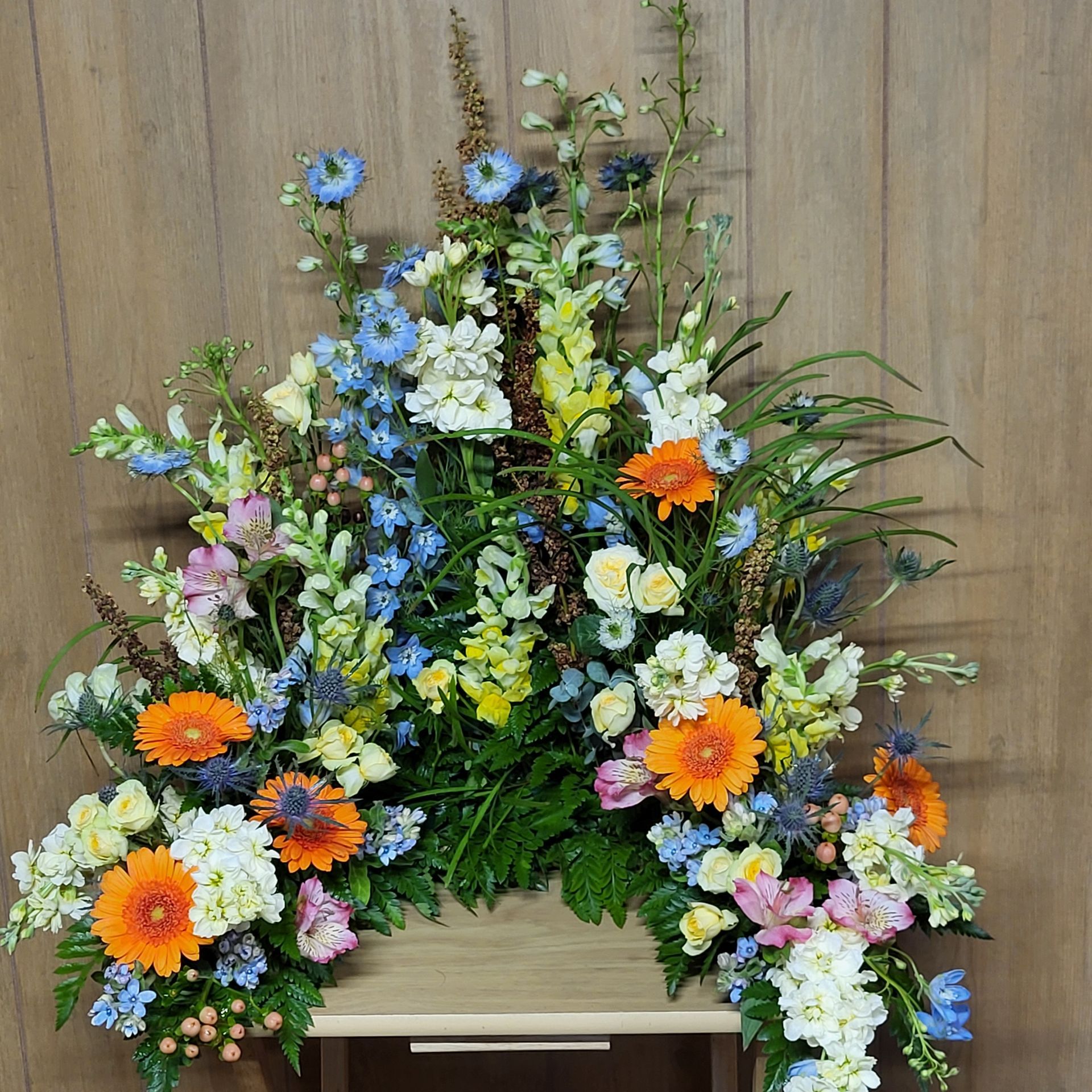 A bunch of flowers are sitting on a wooden table.