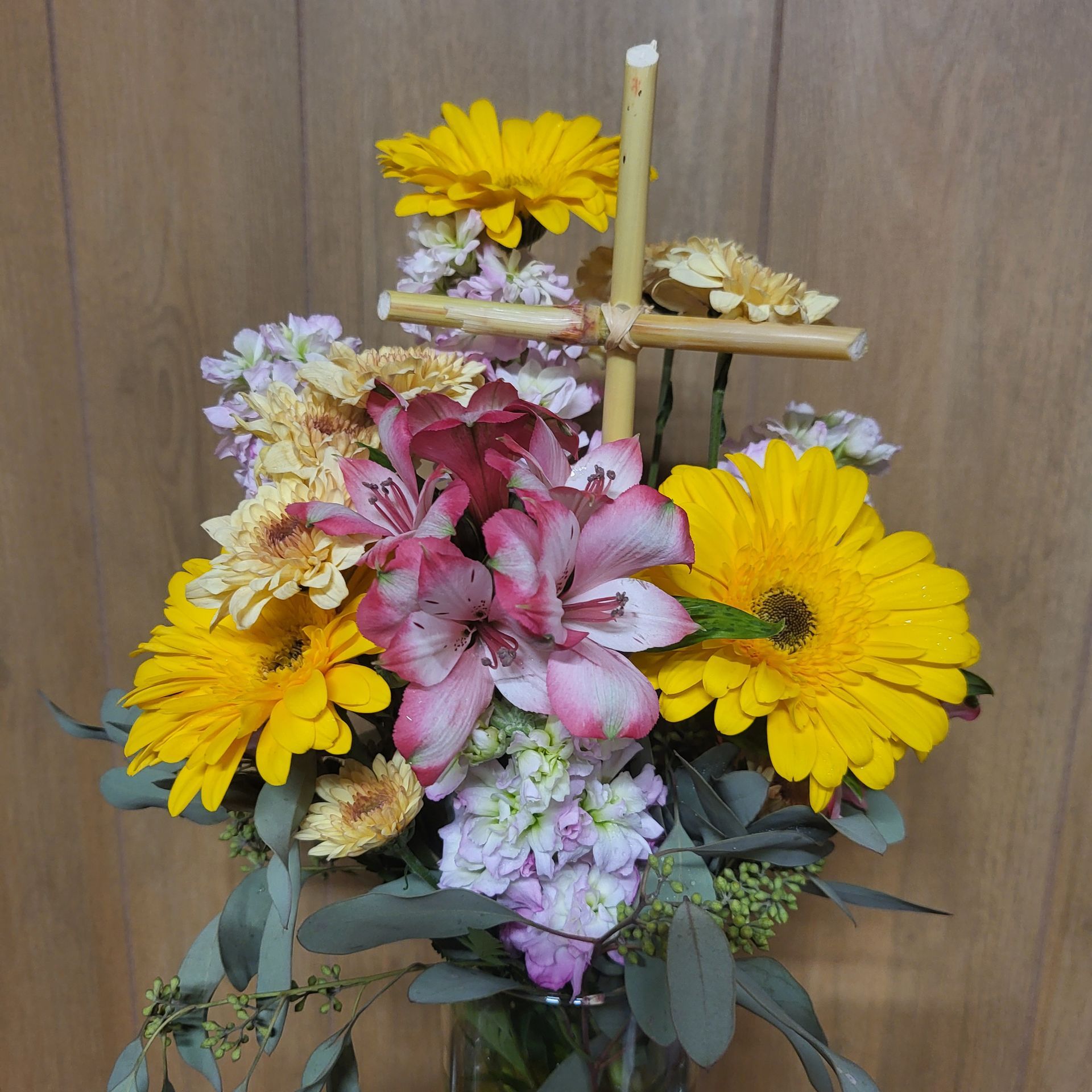 A bouquet of flowers with a cross in the middle.