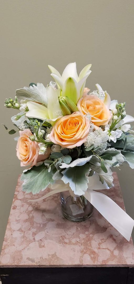 A bouquet of flowers is sitting on a wooden stool.
