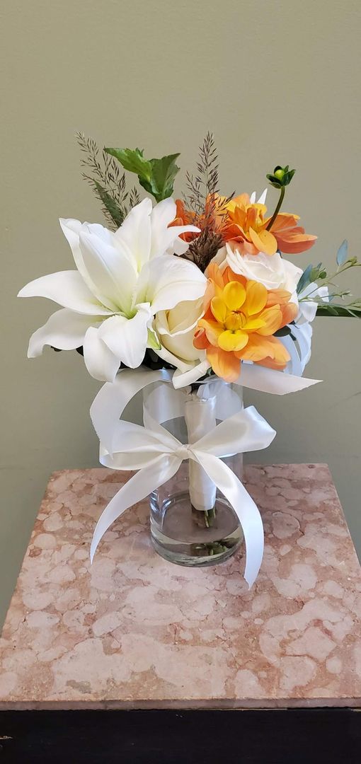 A bouquet of flowers is sitting on a wooden stool.