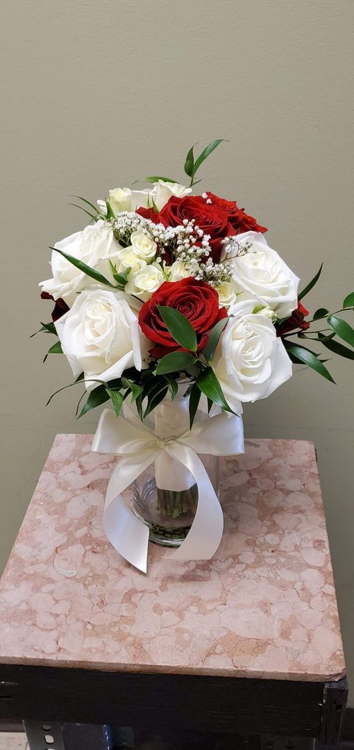 A bouquet of flowers is sitting on a wooden stool.