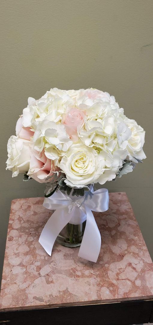 A bouquet of flowers is sitting on a wooden stool.
