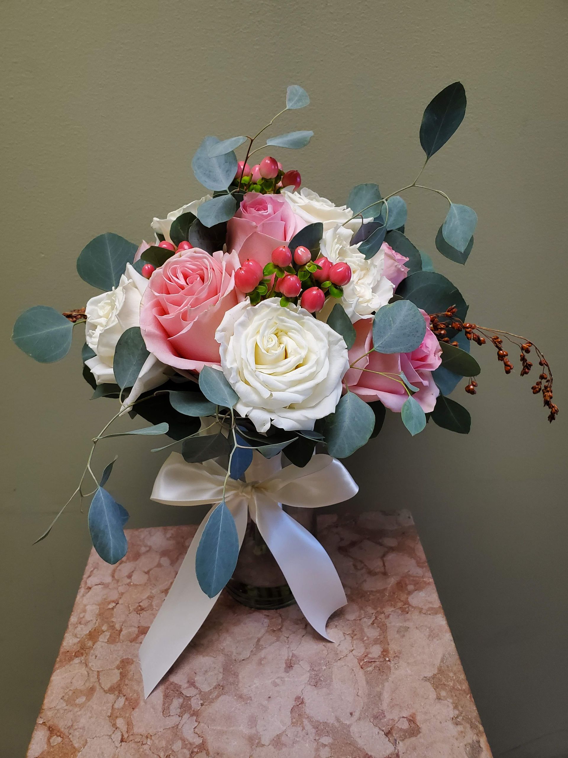 A bouquet of flowers is sitting on a wooden stool.