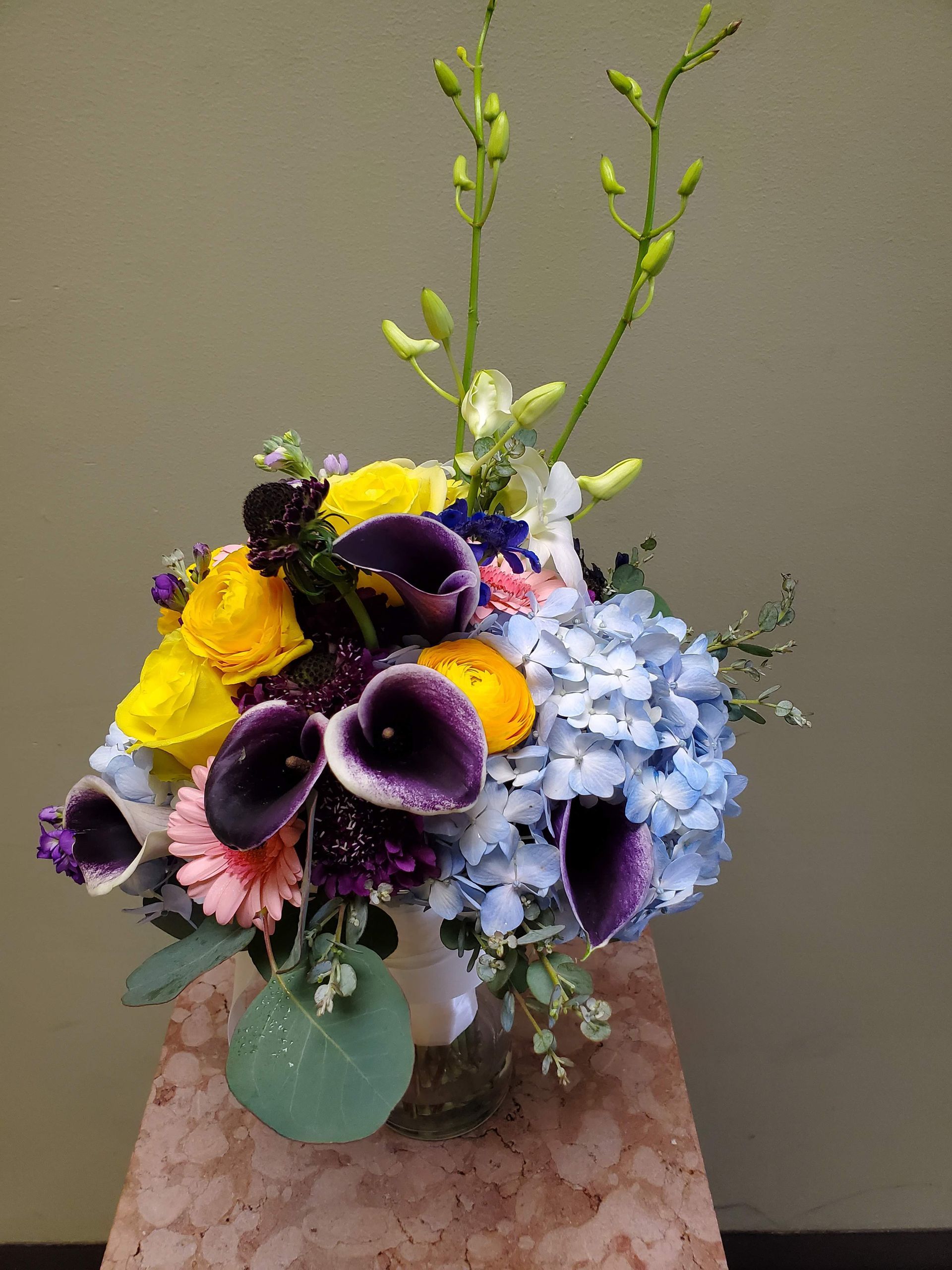 A bouquet of flowers is sitting on a wooden stool.