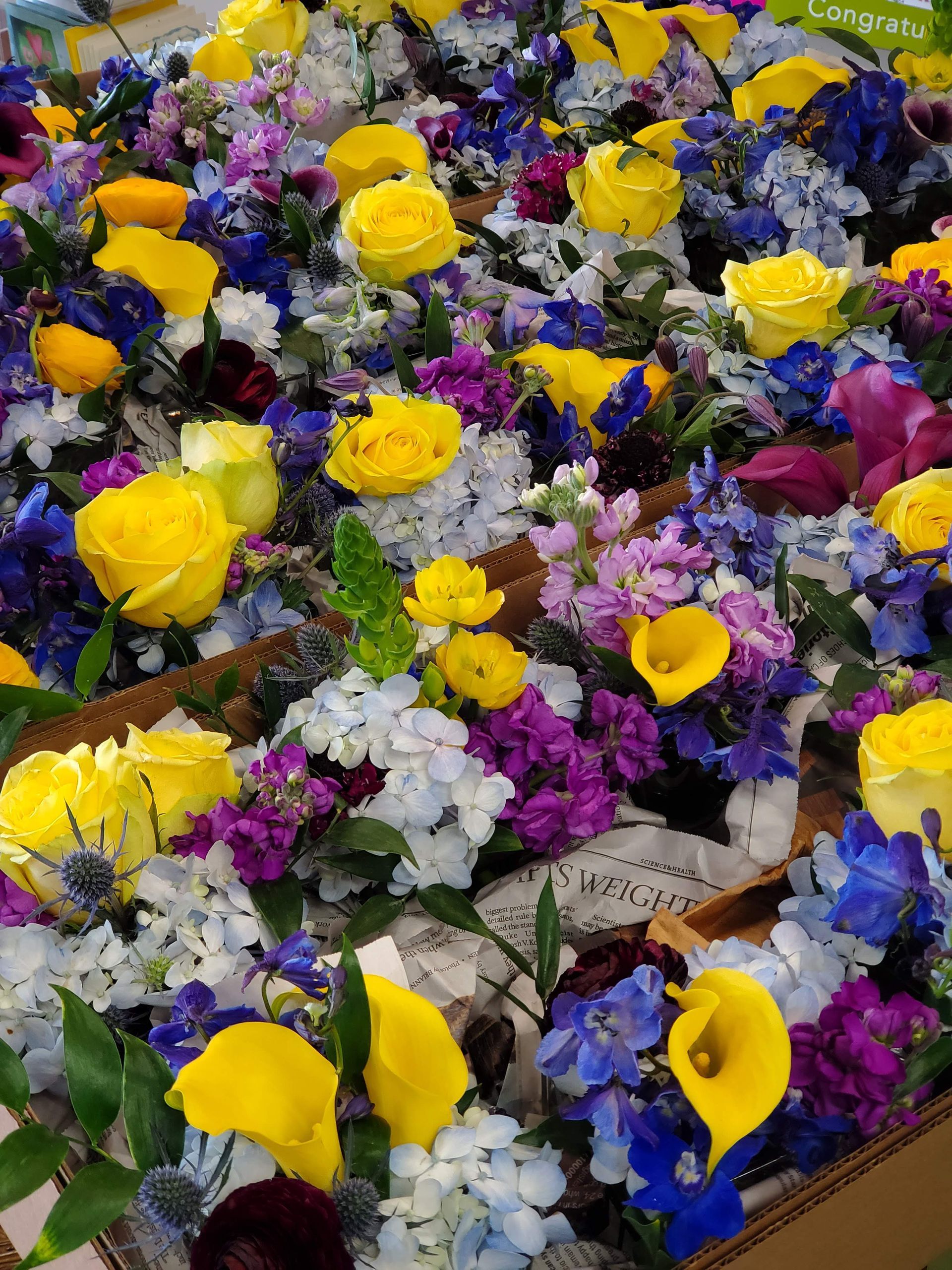 A bouquet of flowers is sitting on a wooden stool.