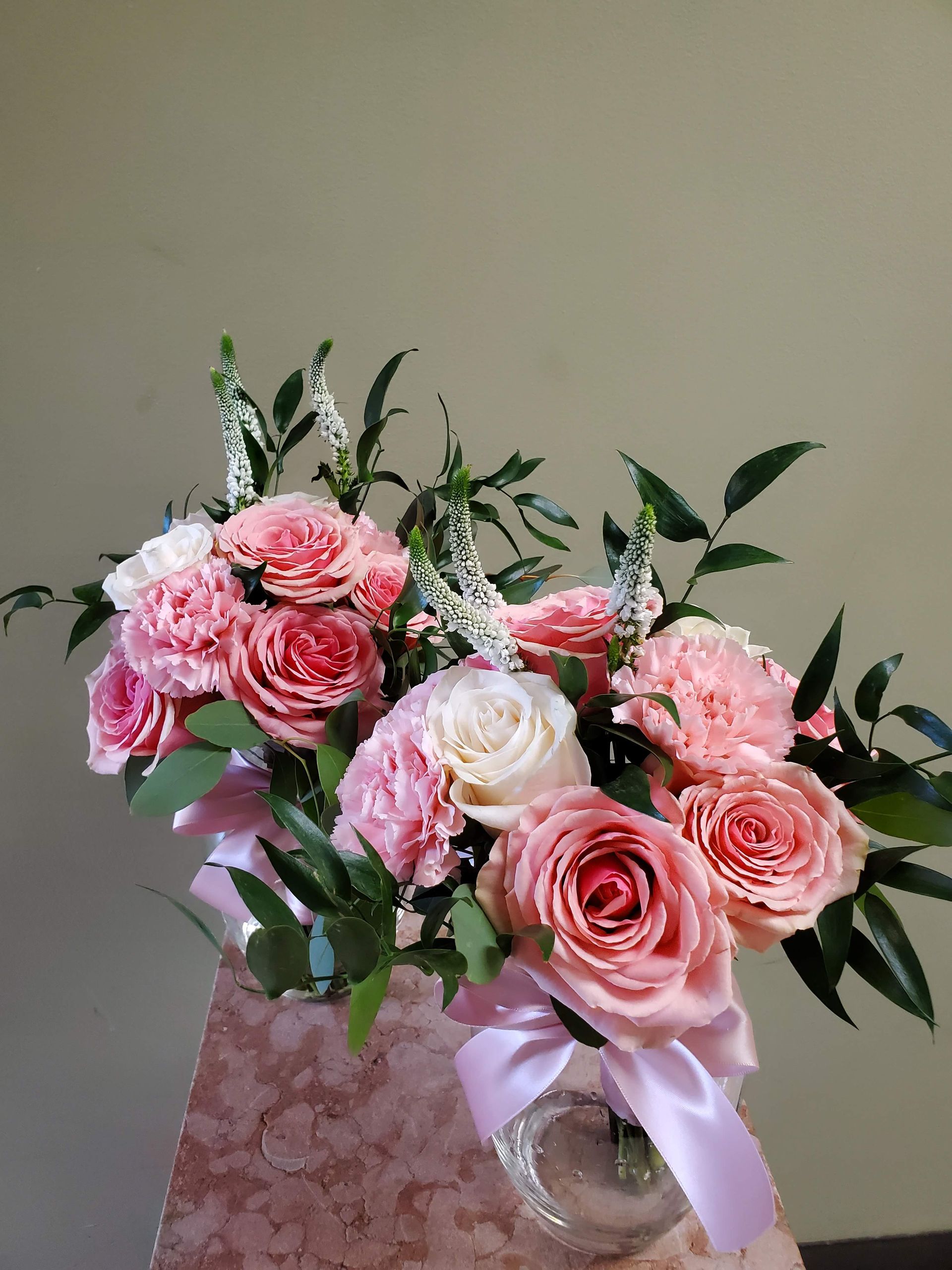 A bouquet of flowers is sitting on a wooden stool.