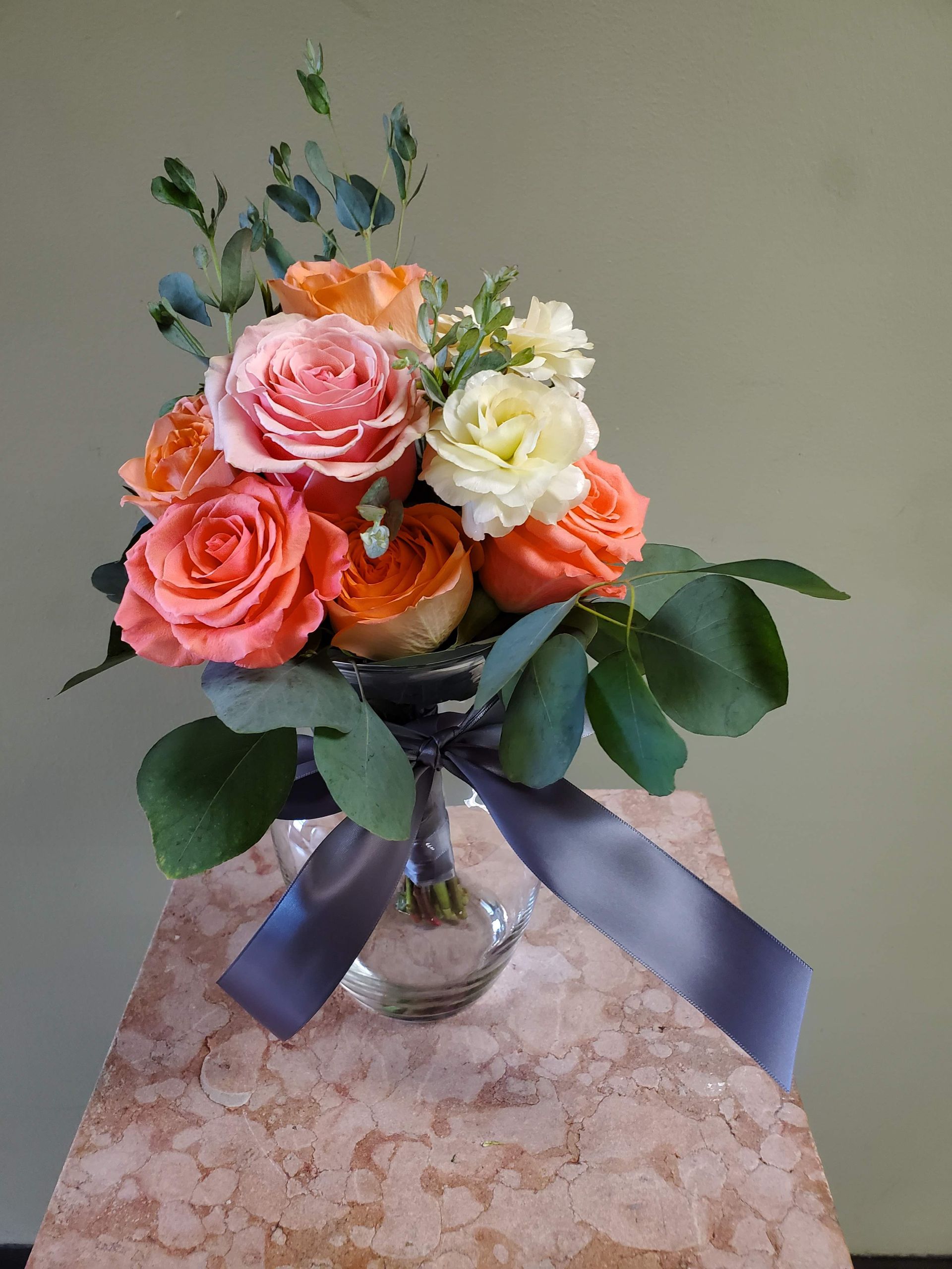 A bouquet of flowers is sitting on a wooden stool.
