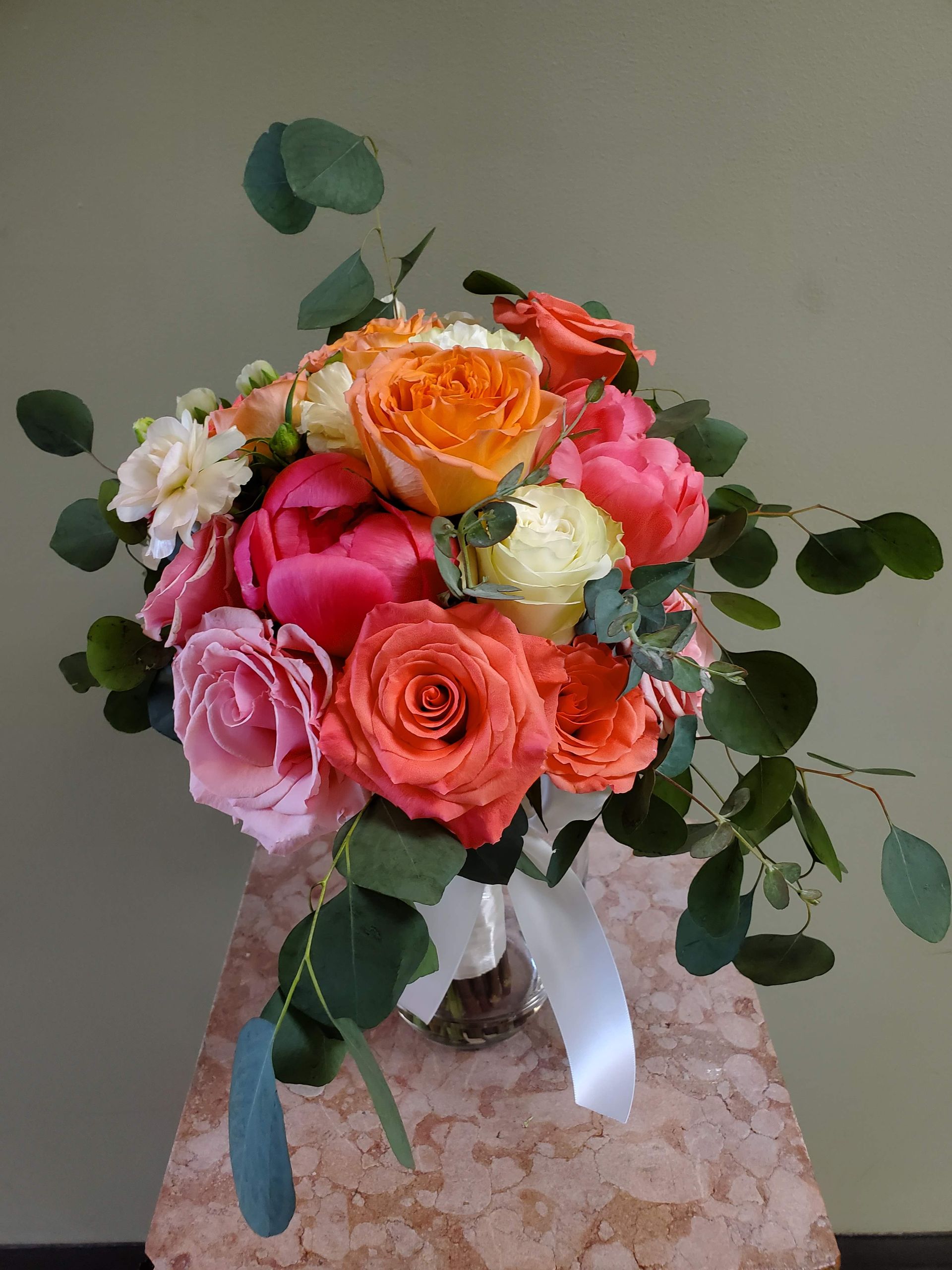 A bouquet of flowers is sitting on a wooden stool.