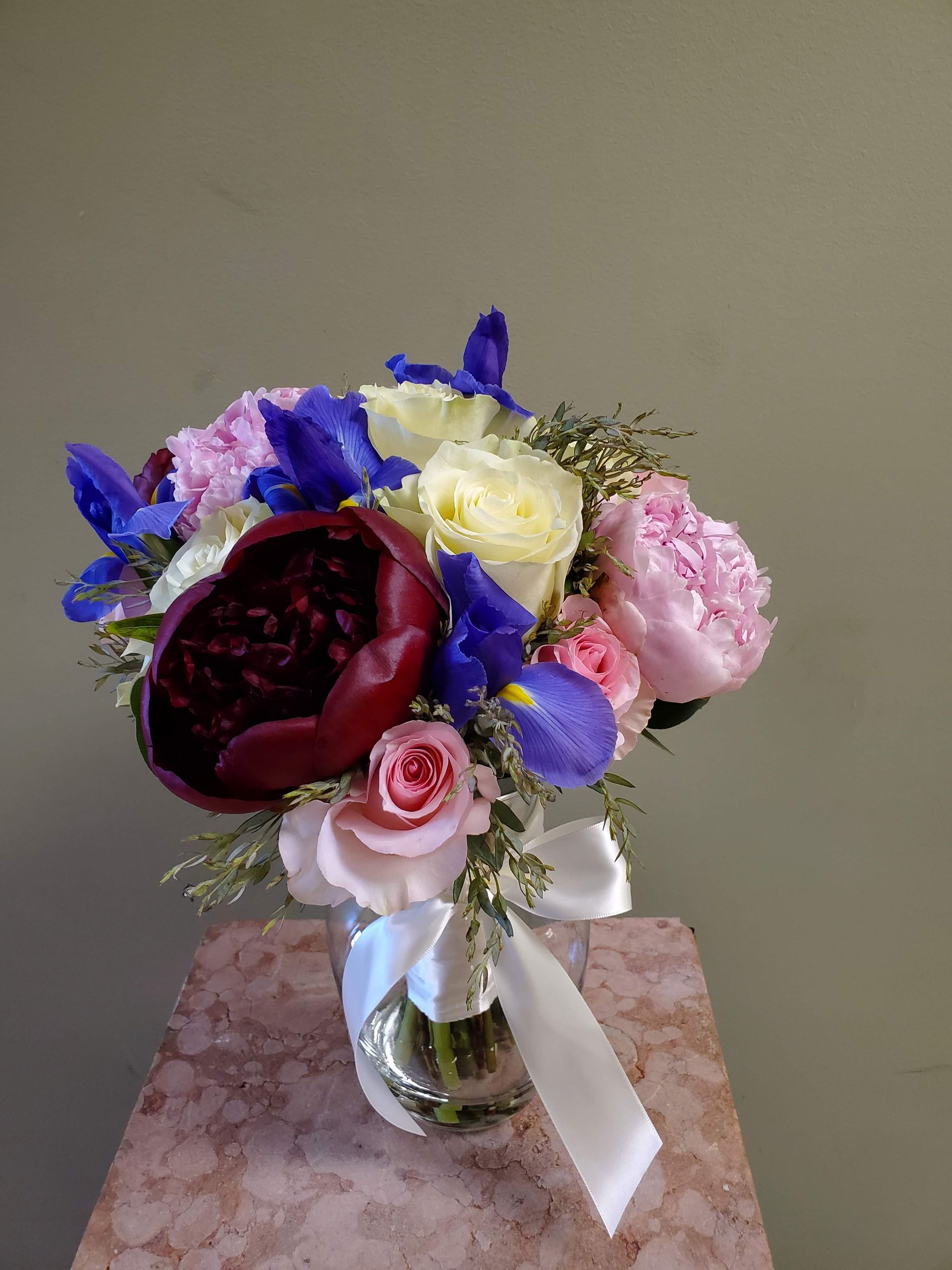 A bouquet of flowers is sitting on a wooden stool.