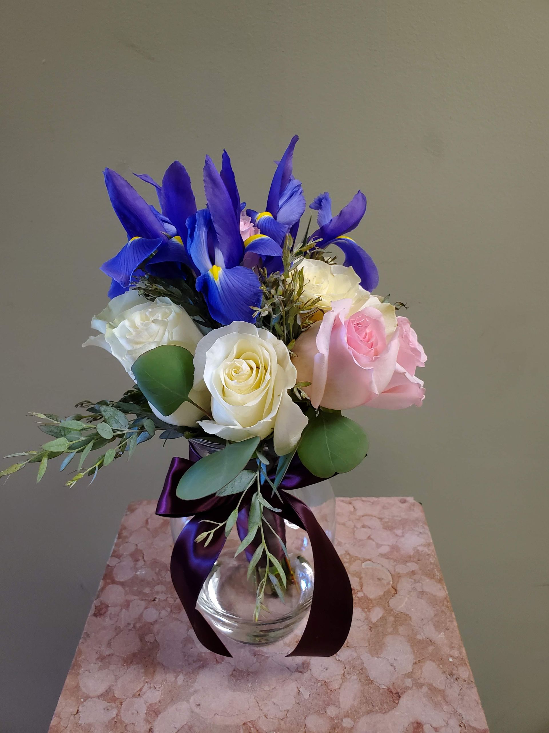 A bouquet of flowers is sitting on a wooden stool.